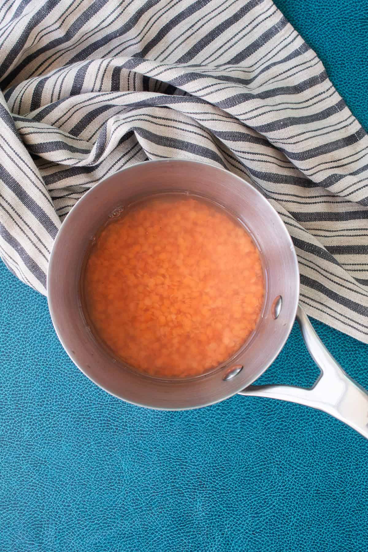 The red lentils are covered with water before cooking on the stovetop.