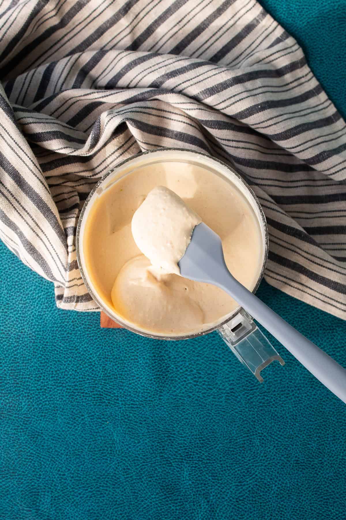The processed hummus has a pale yellow color and smooth texture.
