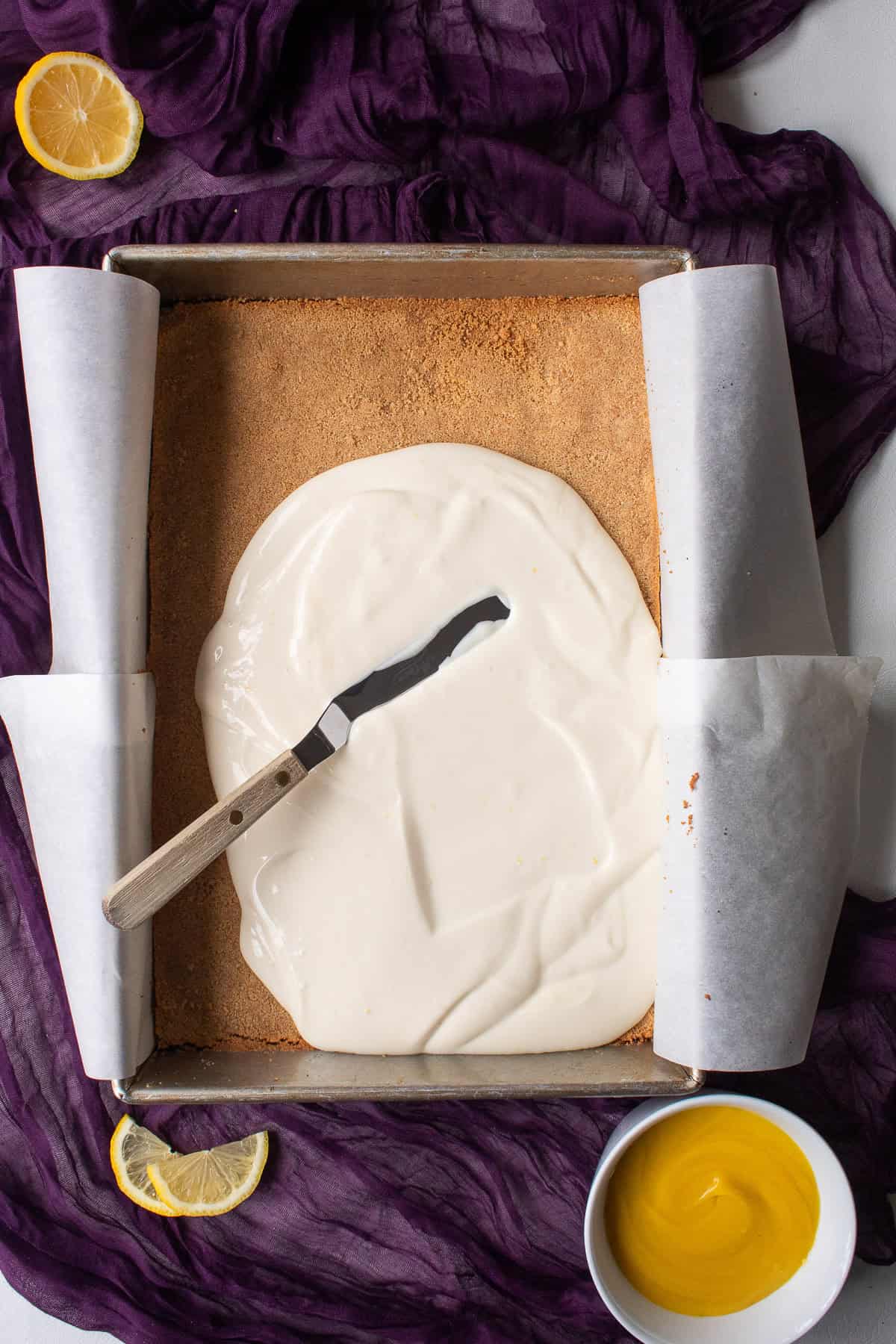 The cheesecake filling is spread over the cooked graham cracker crust.