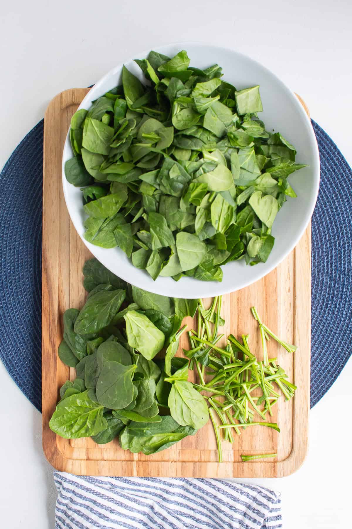 The spinach is prepared on a wooden cutting board.