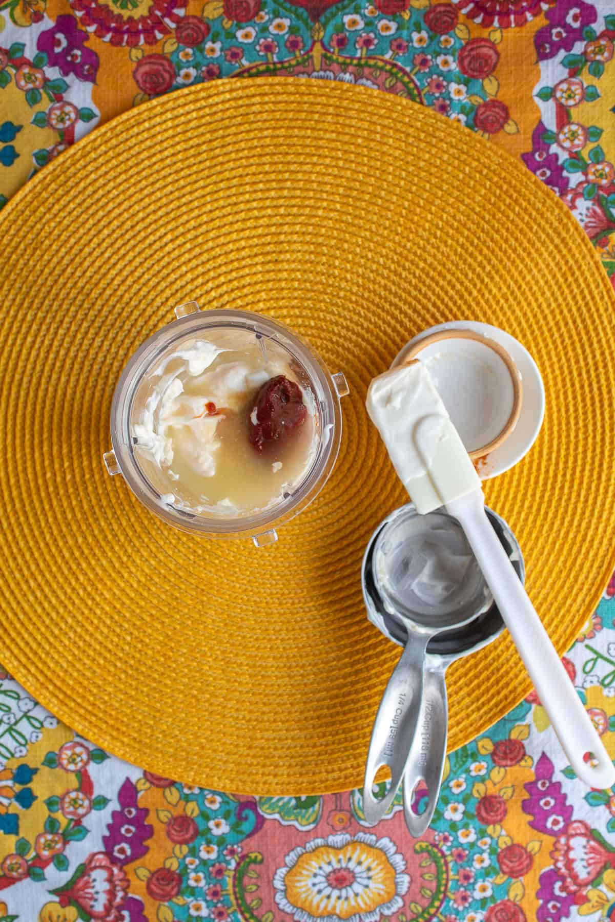 Ingredients for the chipotle crema are added to a blender cup.