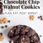 A white dish is stacked with baked cookies. a white text box at the top of the image contains the words, "chocolate chocolate chip walnut cookies" and "plan. eat. post. repeat."