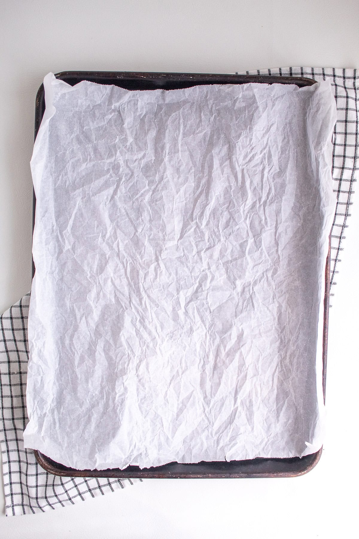 A sheet pan is lined with crinkly white parchment paper.