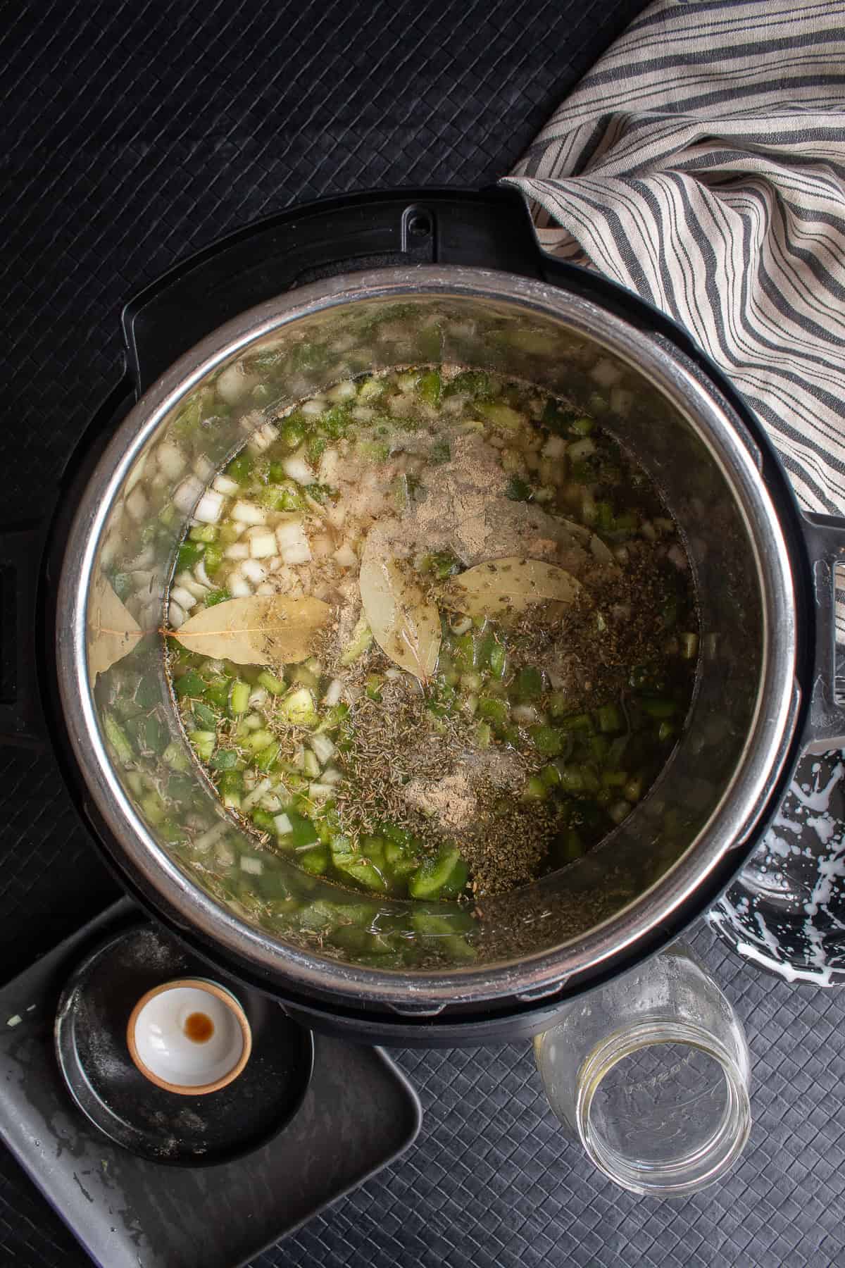 Vegetable stock and liquid smoke are added to the pressure cooker insert.