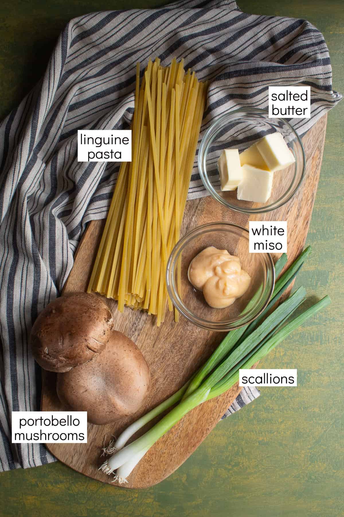Ingredients for the pasta are displayed on a wood surface and have text boxes for each ingredient, including linguine pasta, salted butter, white miso, scallions, and portobello mushrooms.