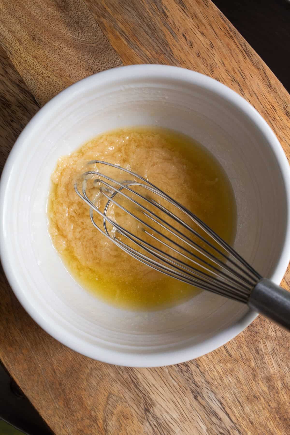 Miso and butter are combined in a white bowl for a curdled looking mixture.