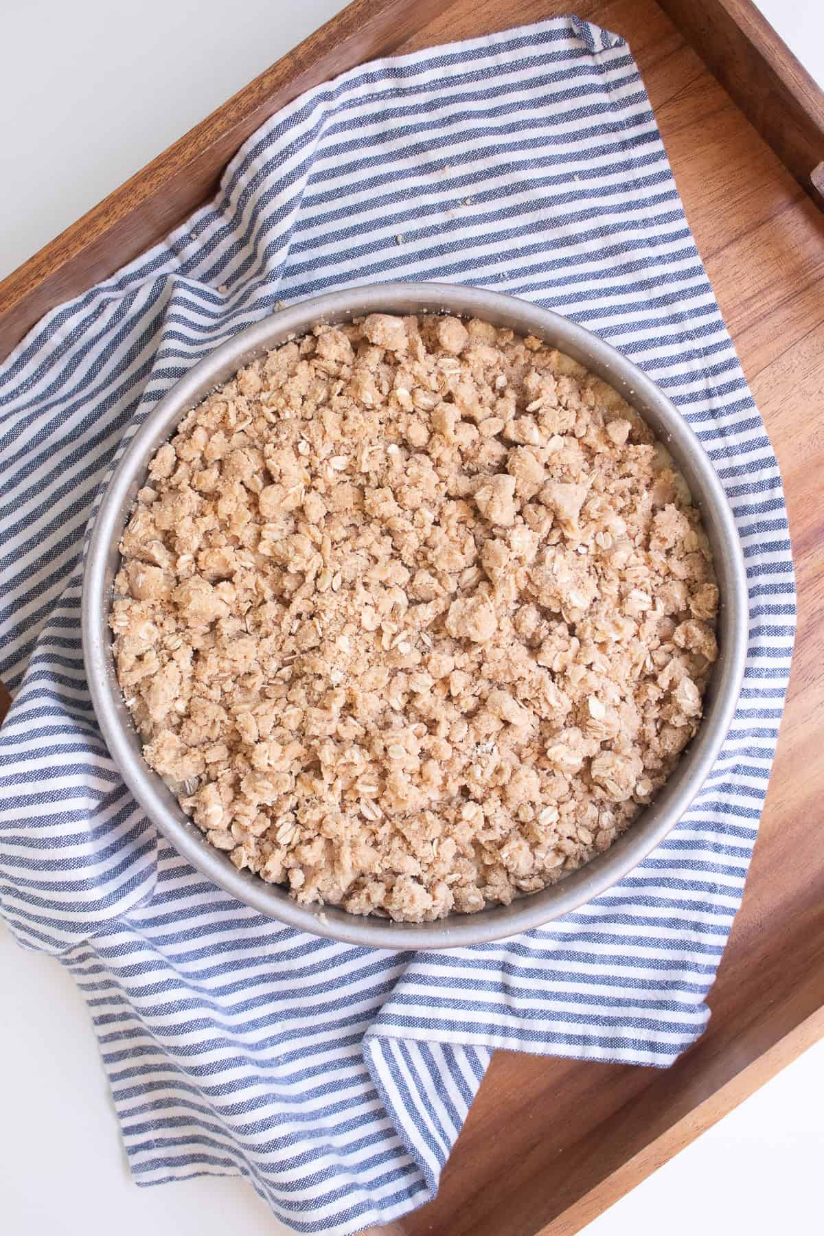 The crumble is sprinkled on top of the batter before baking.