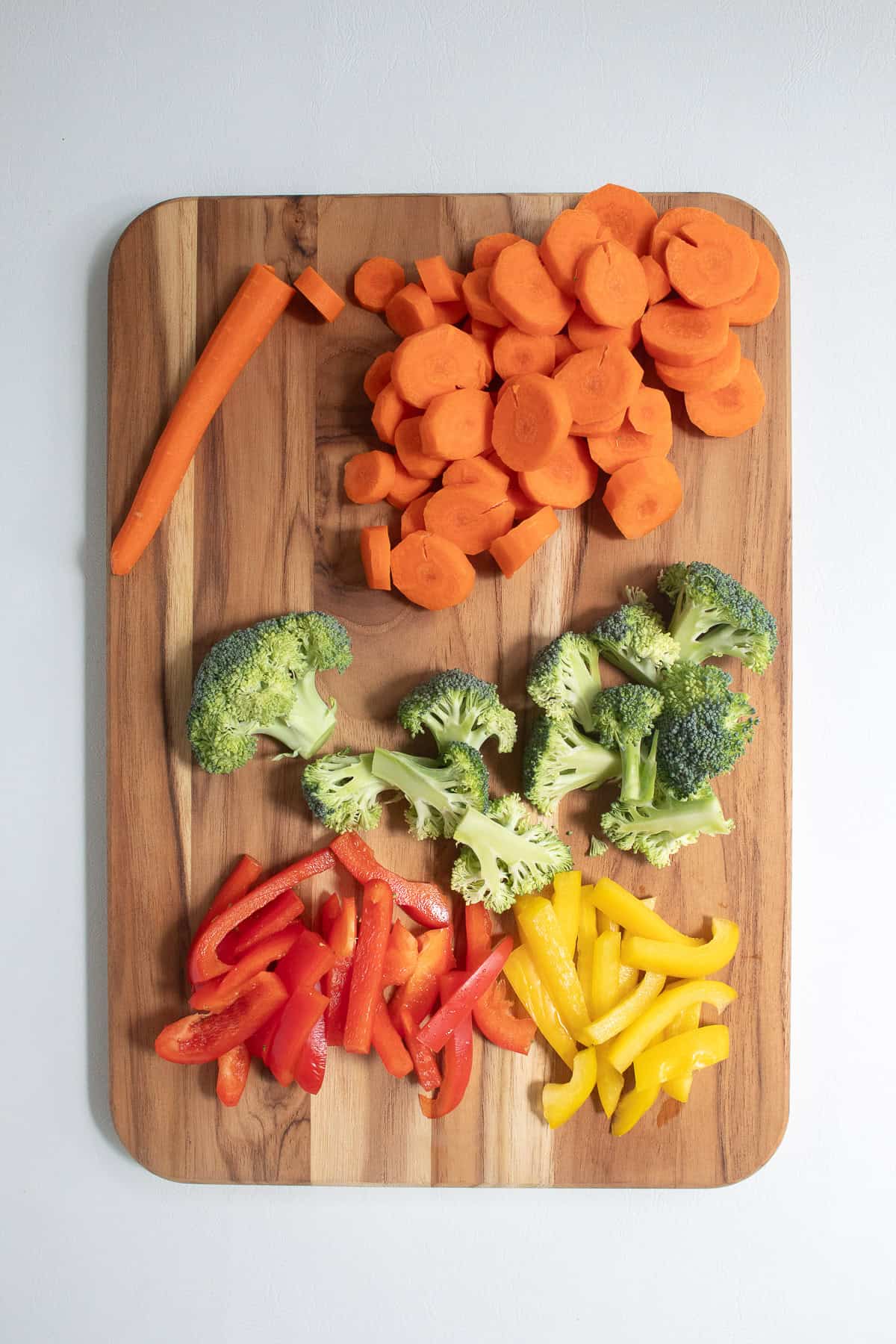 The carrots, broccoli, and bell peppers are cut to bite-sized pieces.