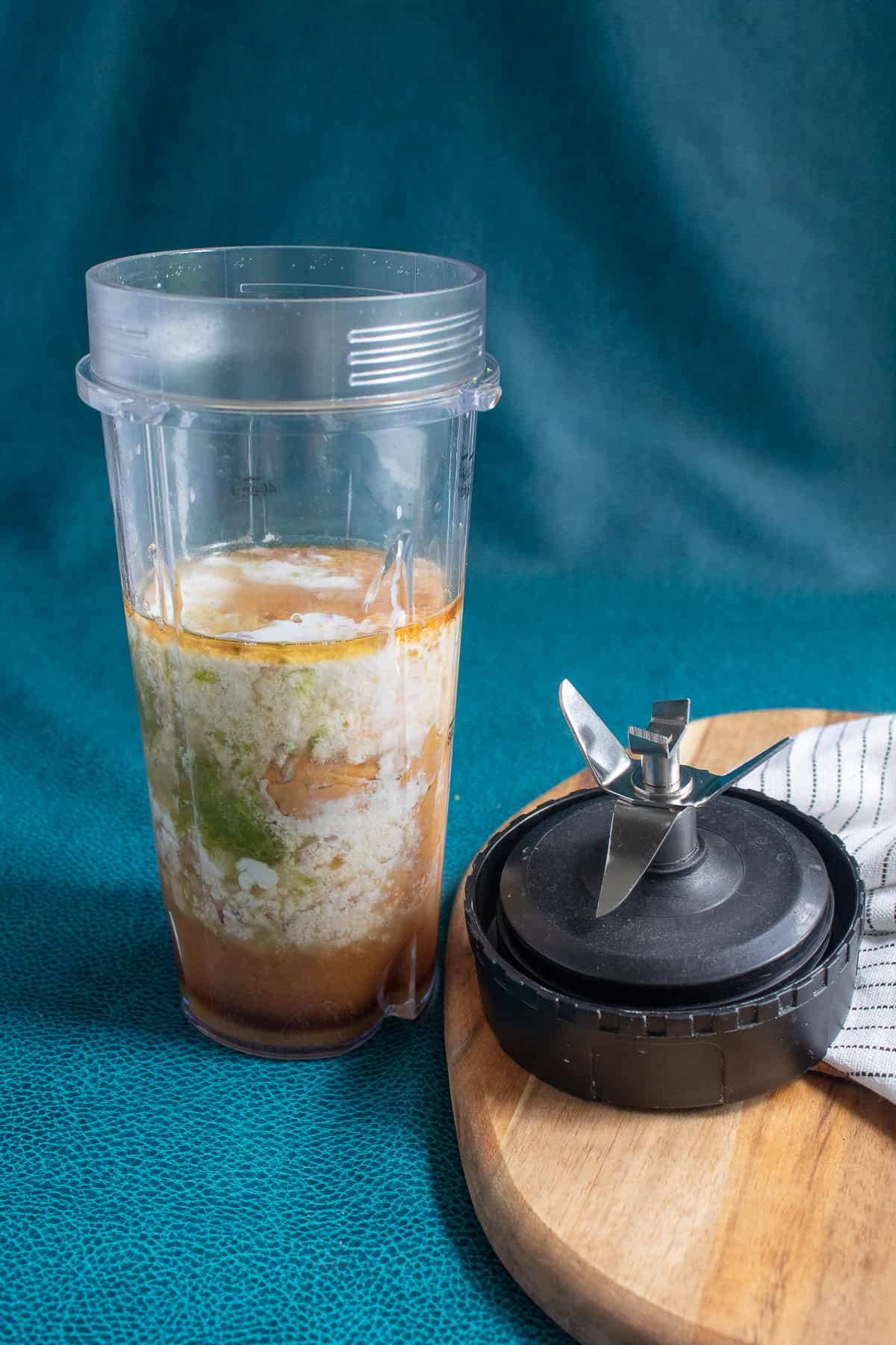 The ingredients for the peanut sauce are added to a mini blender cup.