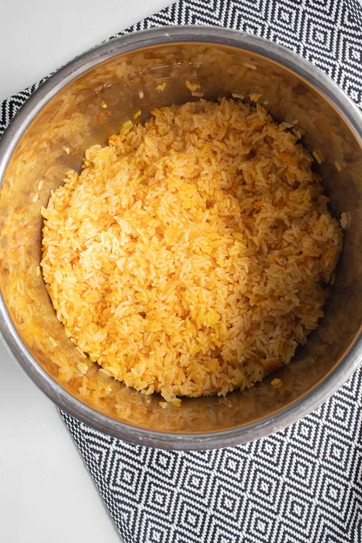 The cooked saffron rice is fluffed and is now a golden yellow color.