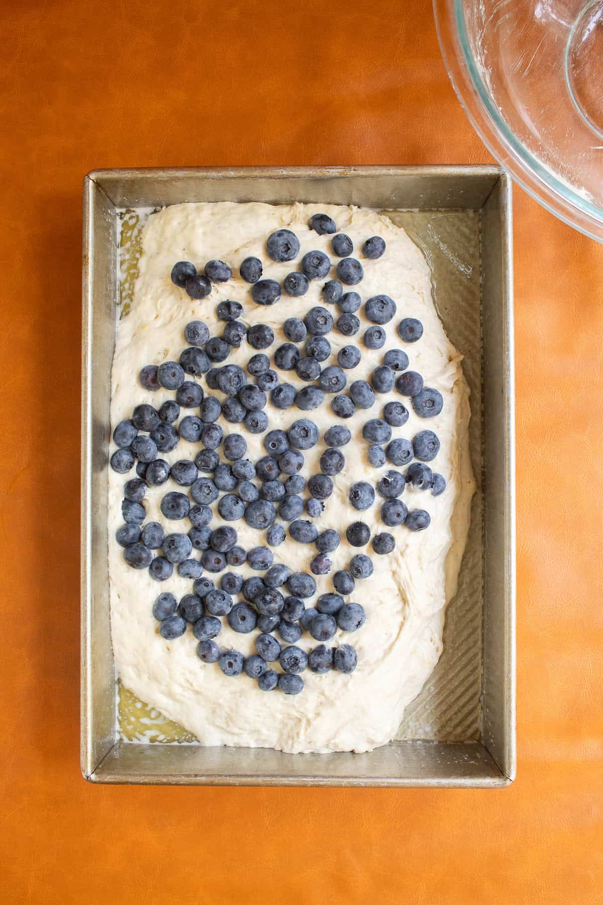 Fresh blueberries are sprinkled over the top of the dough.