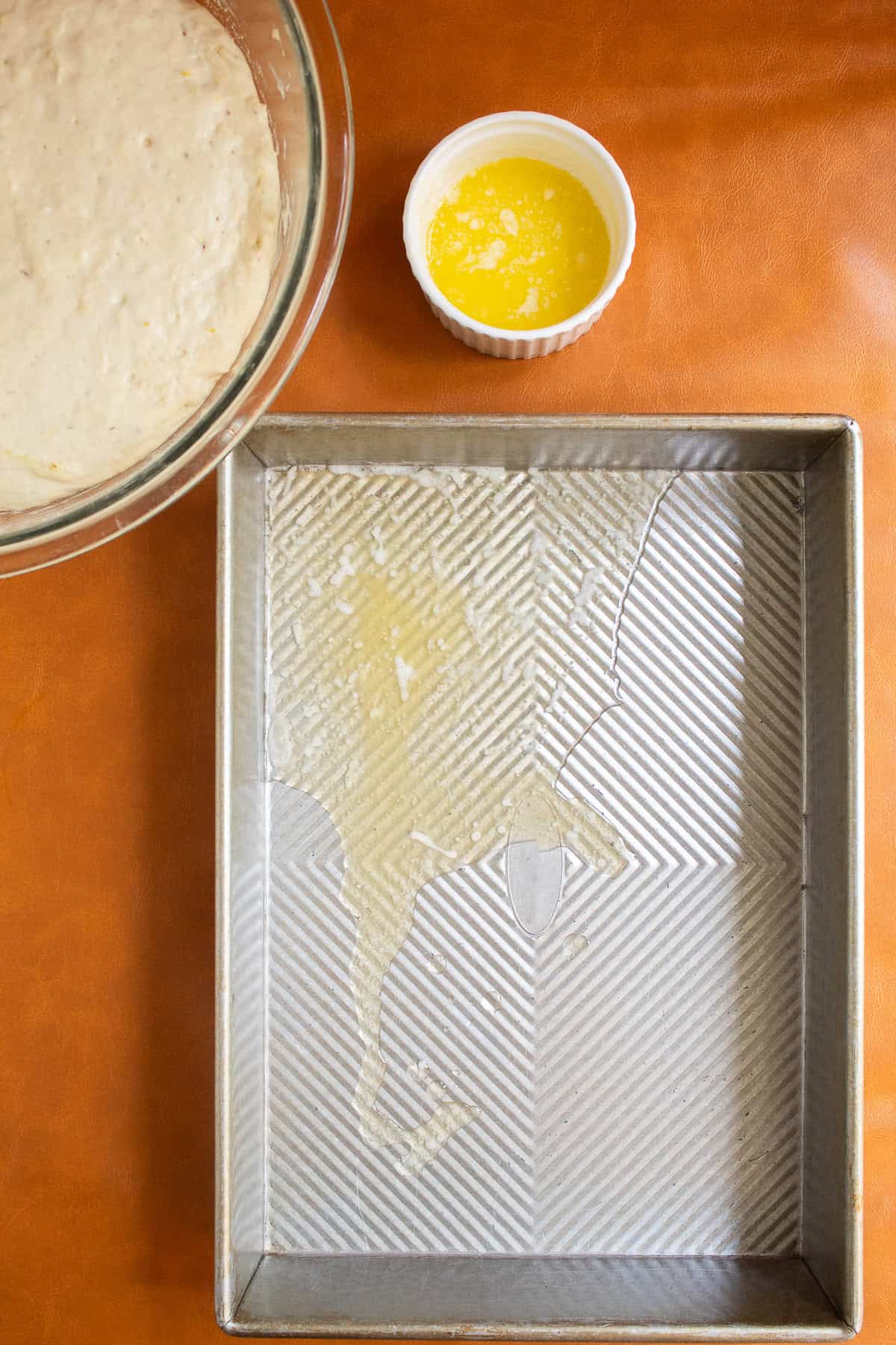 Melted butter and vegetable oil are added to the baking pan.