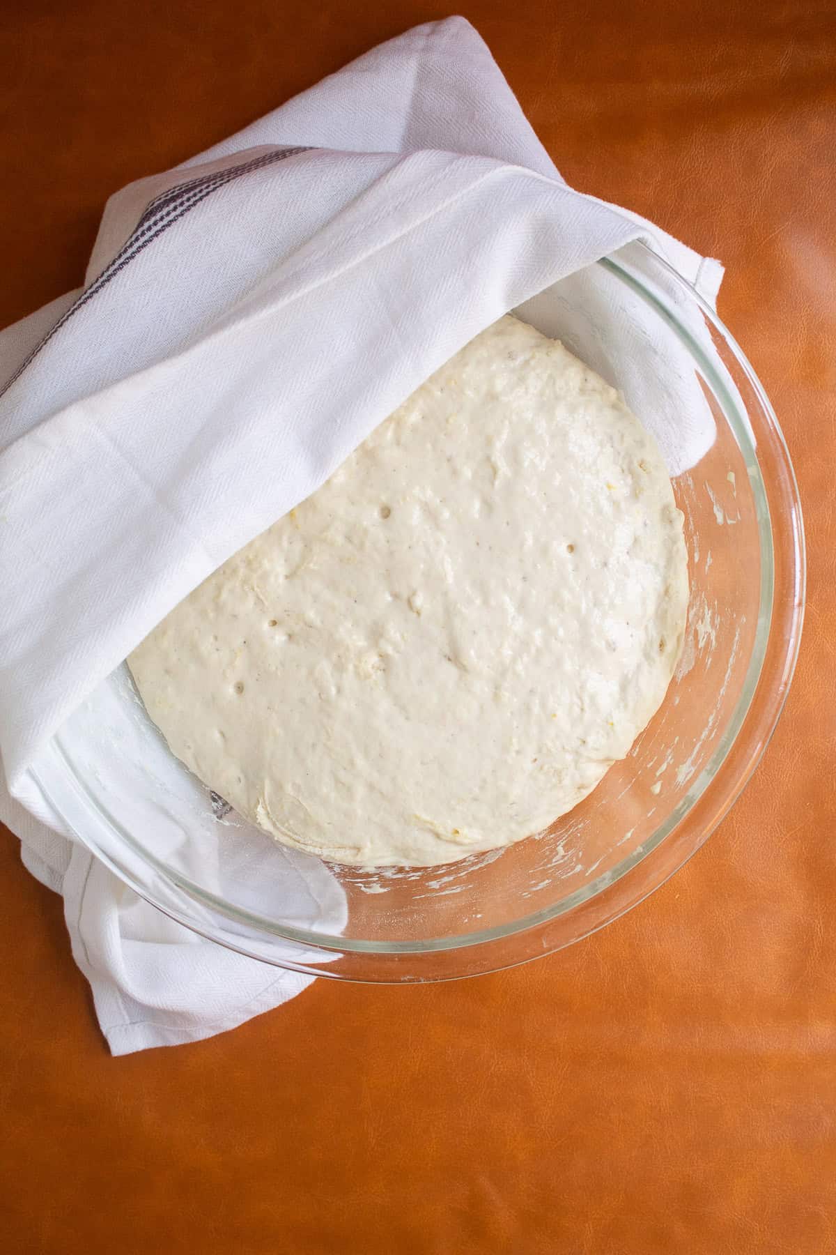The dough has doubled in size in the glass bowl.