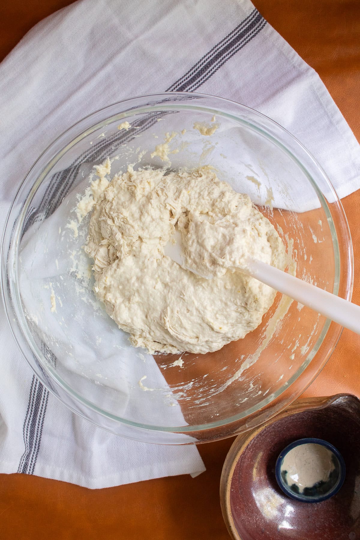 The water, yeast, and four combine to form a wet dough in the bowl.