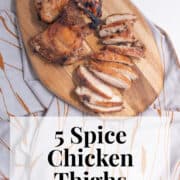 Tender chicken thighs are sliced on a wooden cutting board. A text box at the bottom of the image contains the words, "5 spice chicken thighs" and "plan. eat. post. repeat."