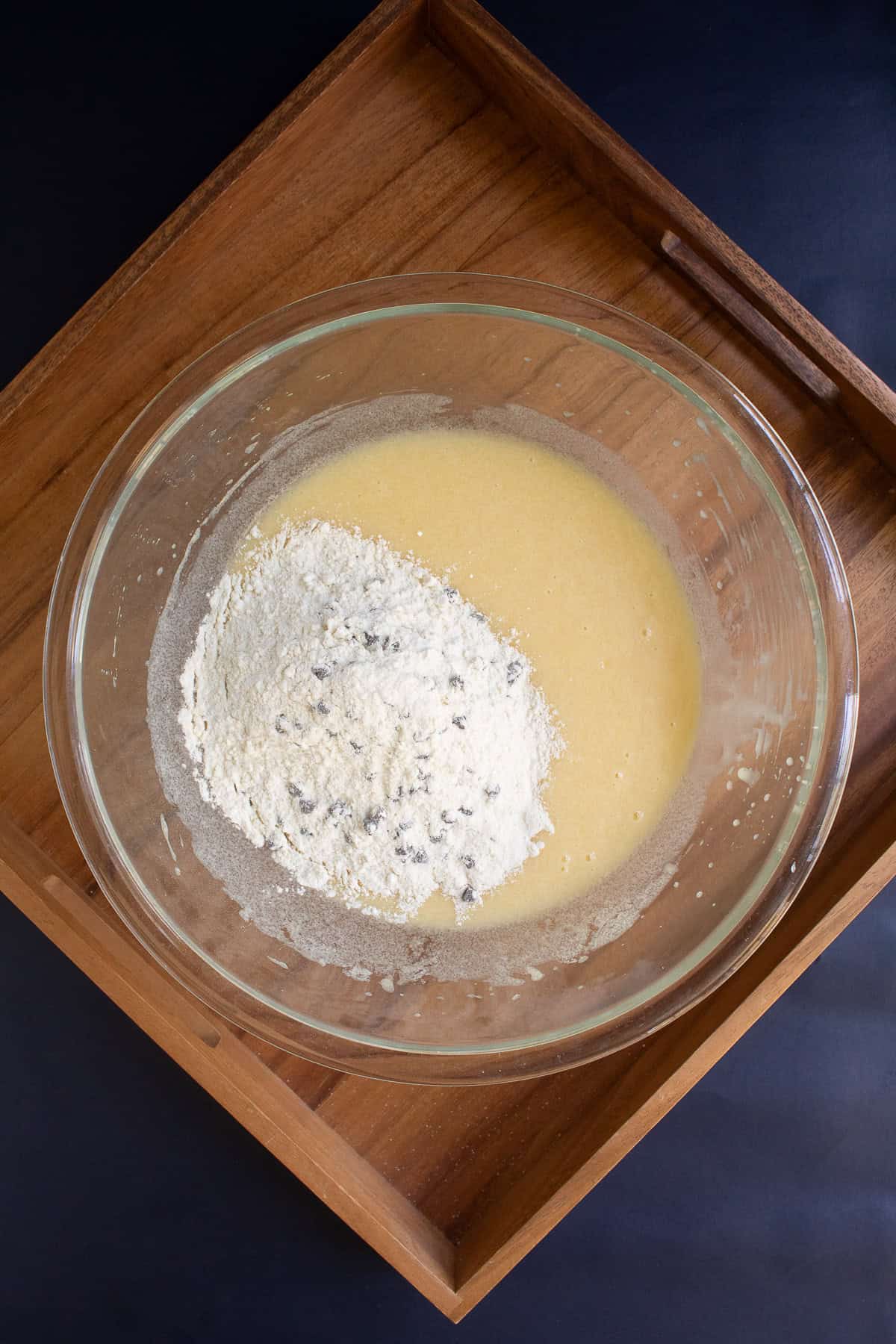The dry ingredients are added to the wet ingredients in a large bowl.