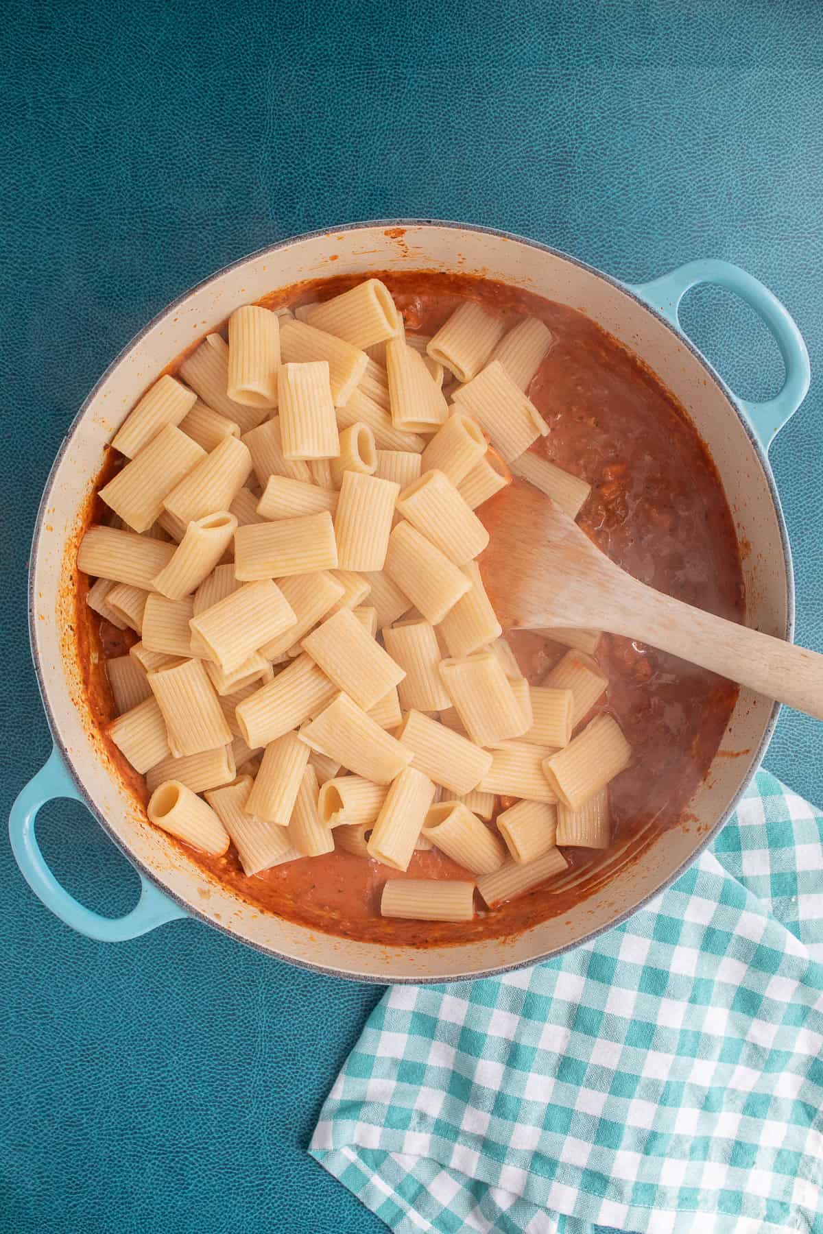 Cooked pasta is added to the creamy sauce.