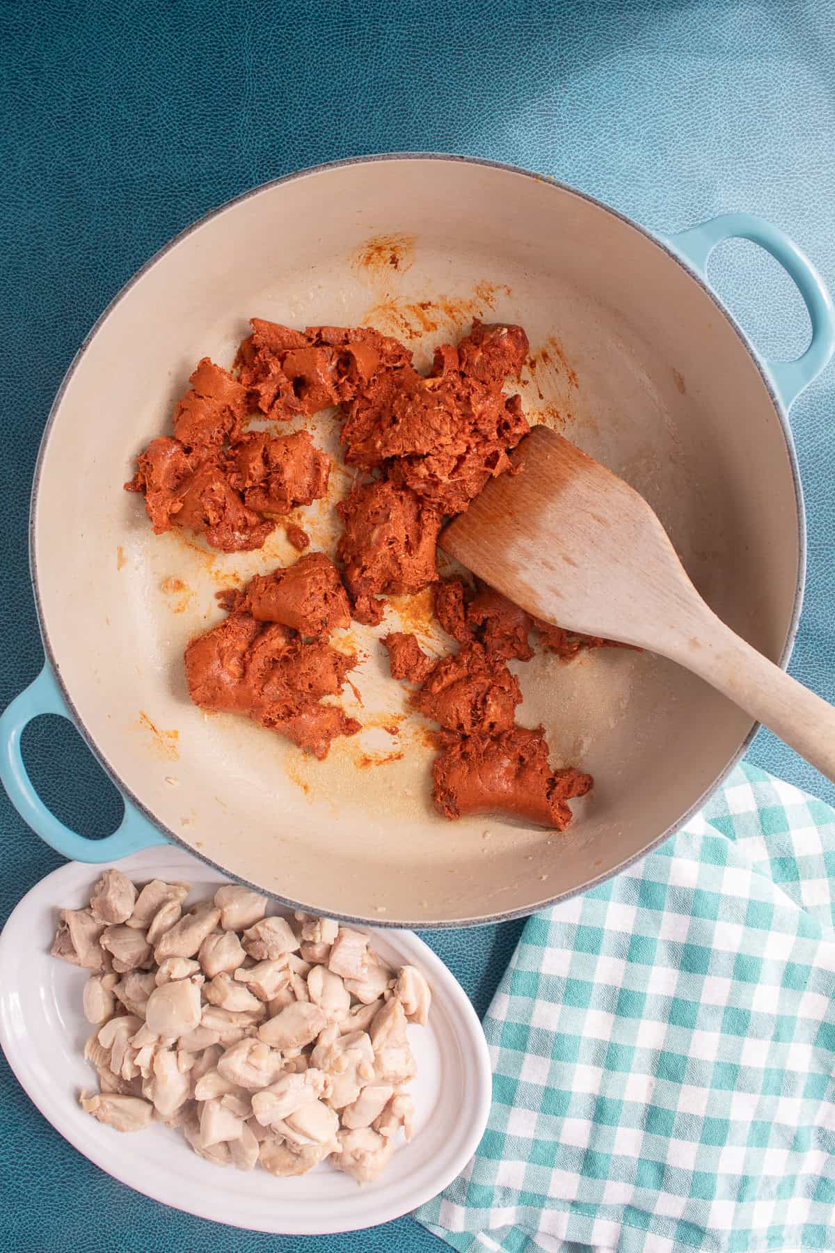 The chorizo is added to the pot and broken into small pieces with a wooden spatula.