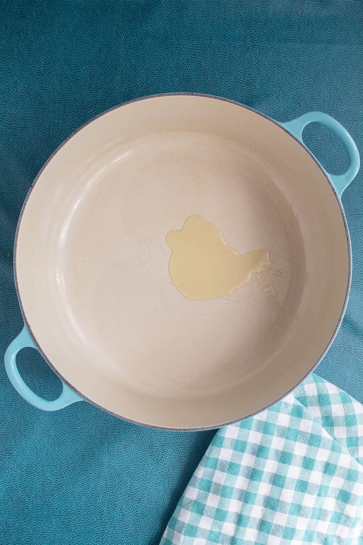 Olive oil is heated in the bottom of a large Dutch oven.