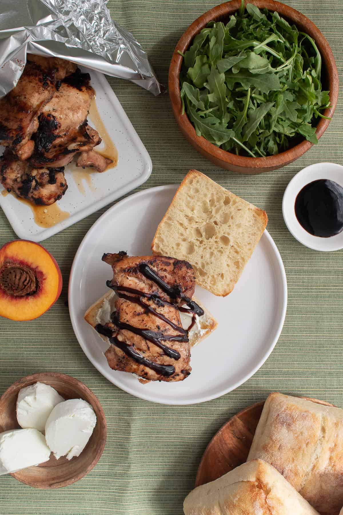 A balsamic chicken thigh is added to the sandwich and drizzled with balsamic glaze.