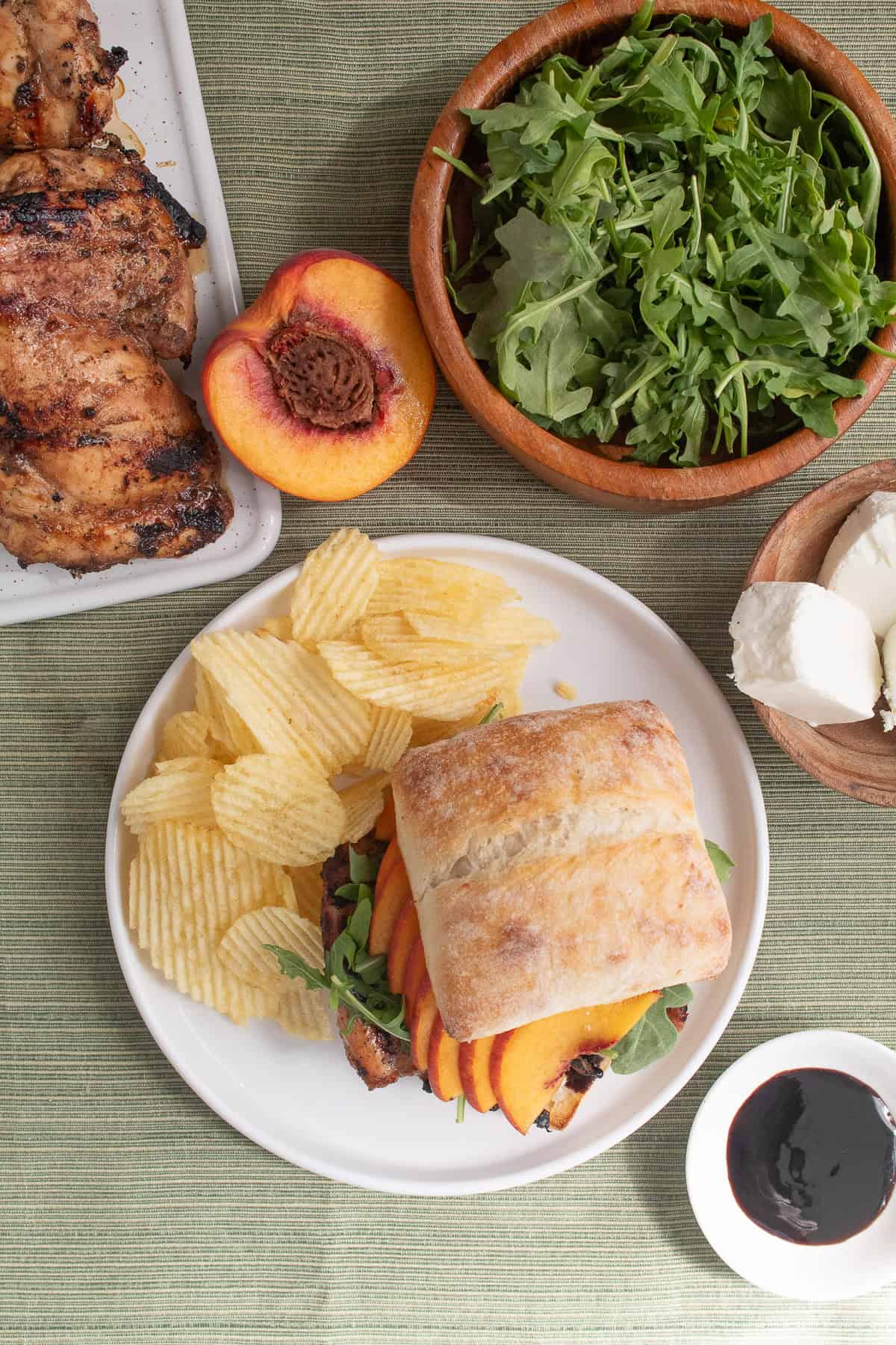 The sandwich is served with potato chips on a white plate.