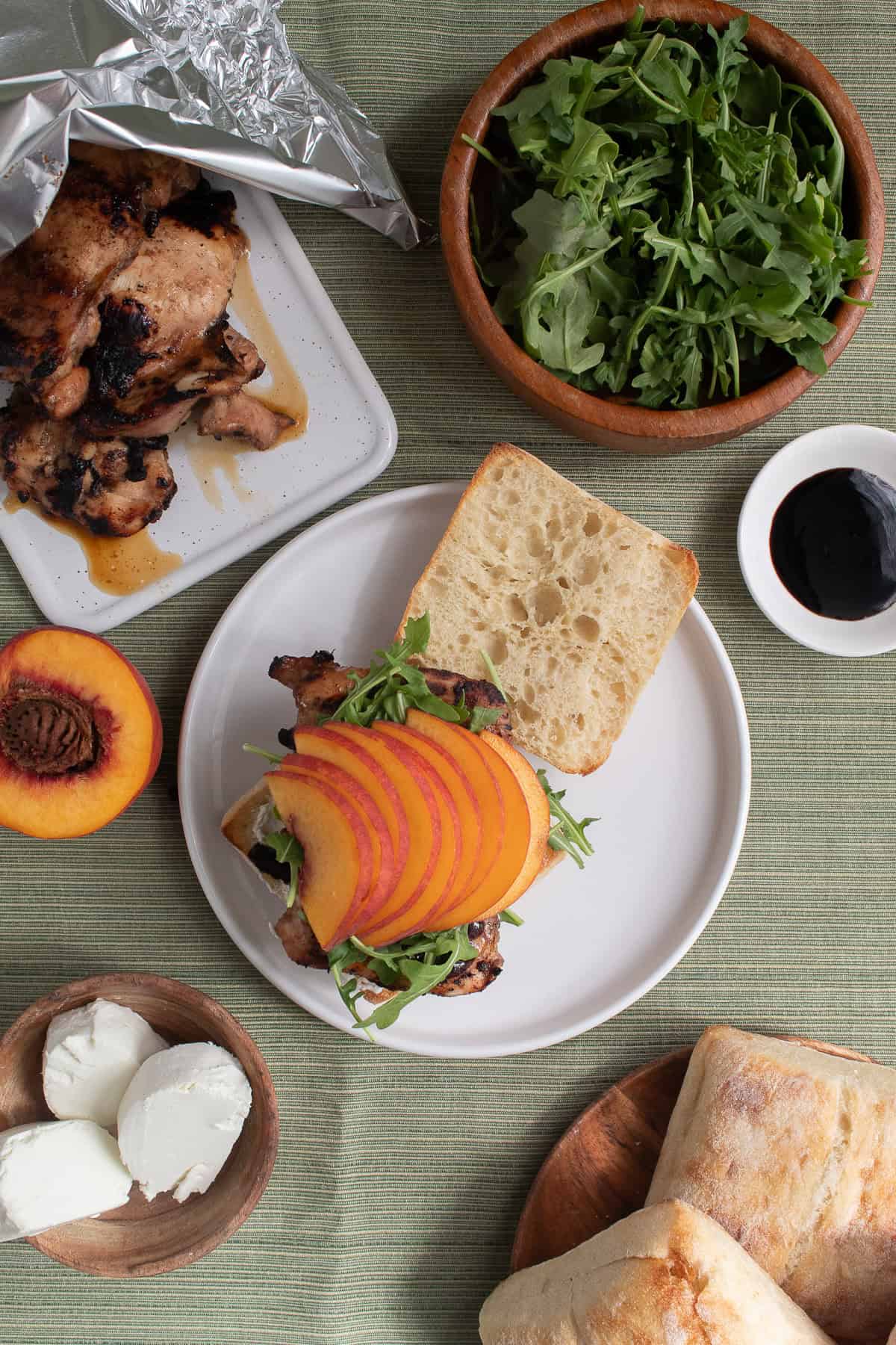 Arugula and sliced peaches are layered on the sandwich.