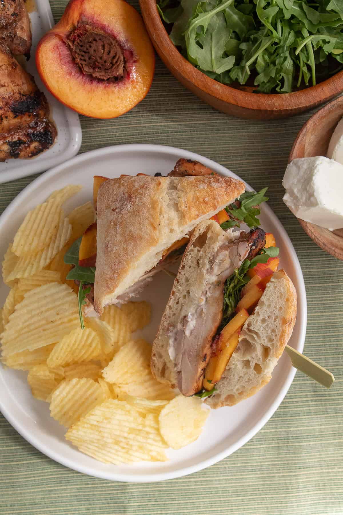 The sandwich is cut in half on a plate, displaying the layers of ingredients.