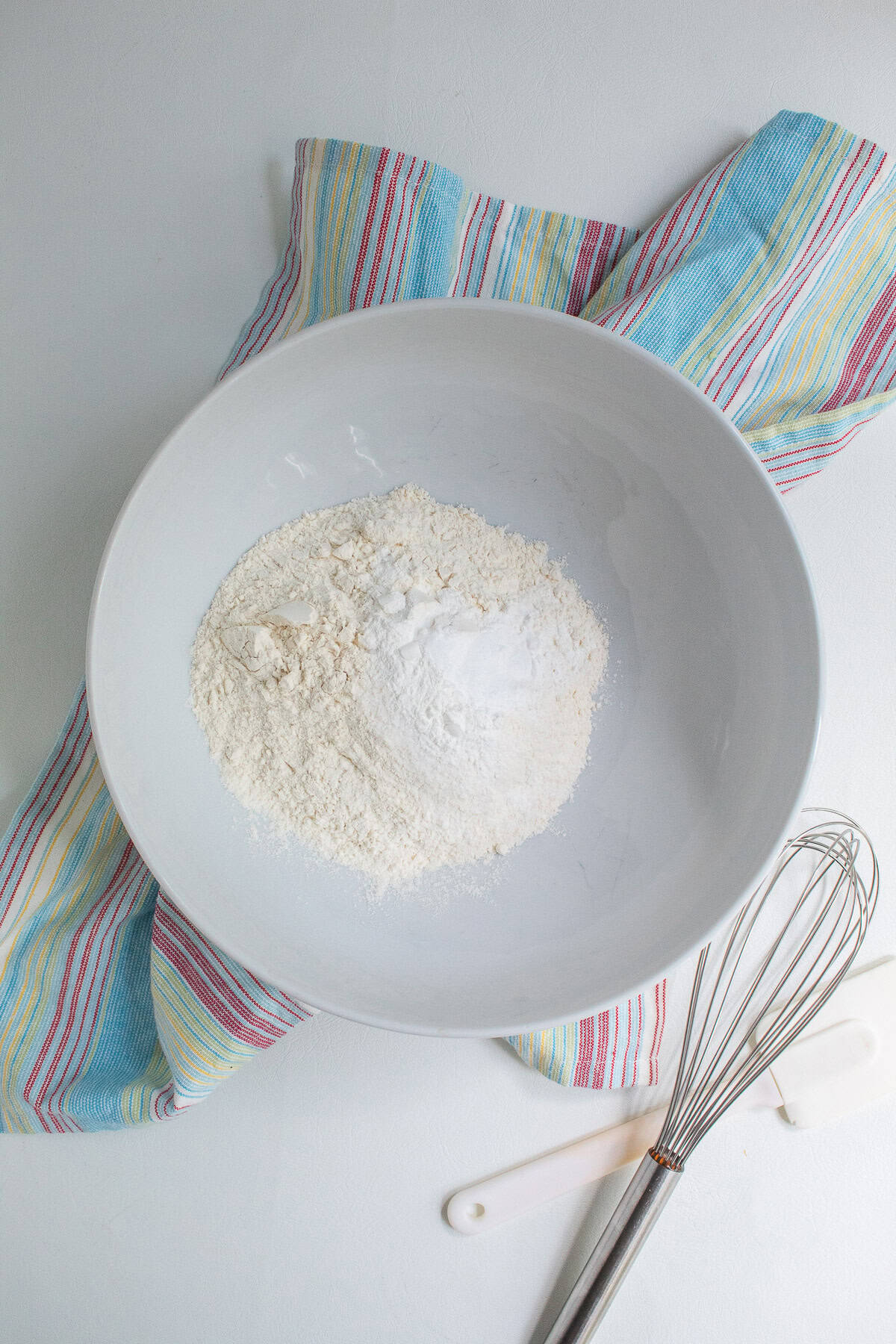 Dry ingredients are added to a large mixing bowl.
