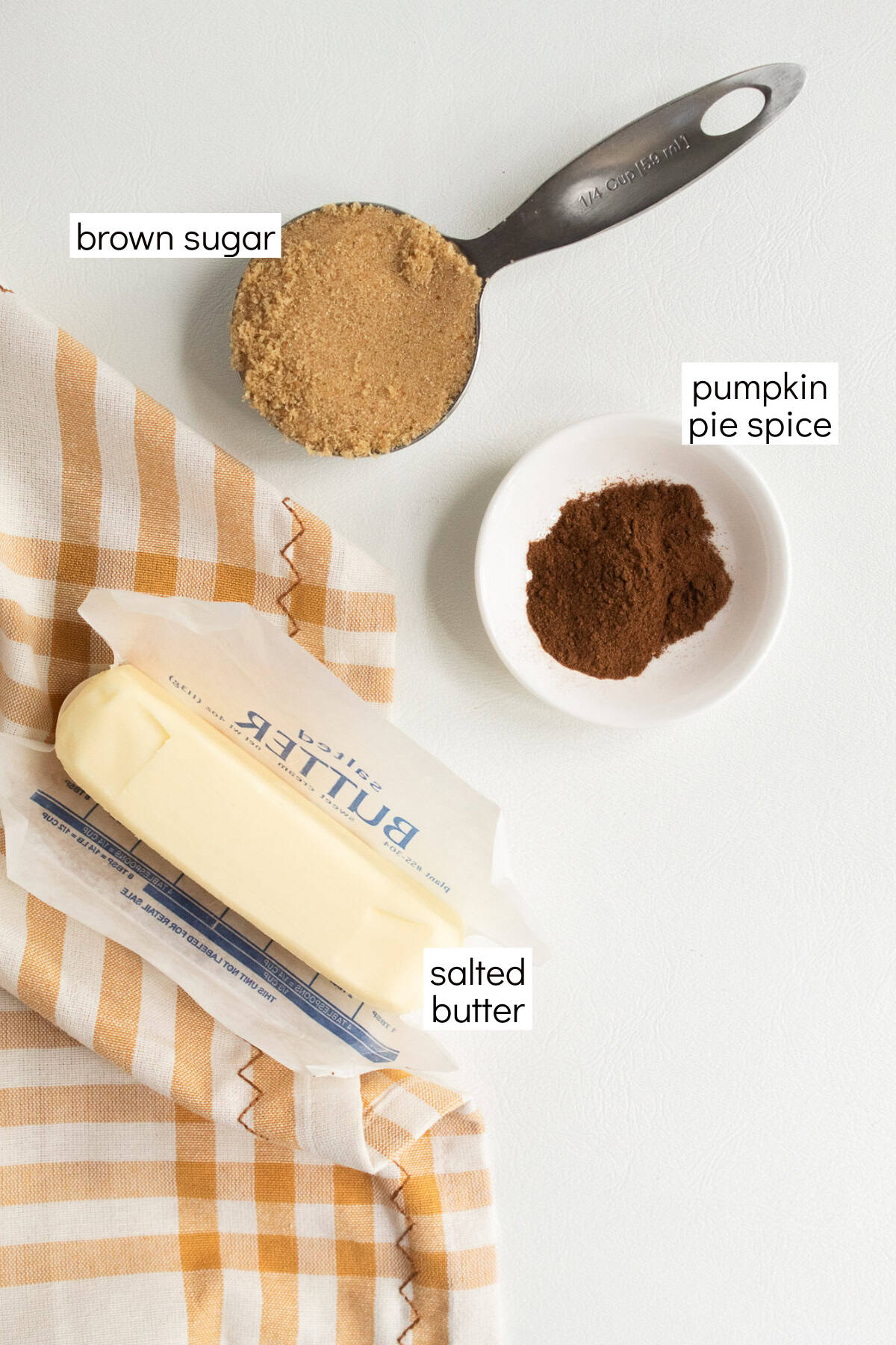 Ingredients for the brown sugar butter are displayed and labeled with white text boxes including the words brown sugar, pumpkin pie spice, and salted butter.