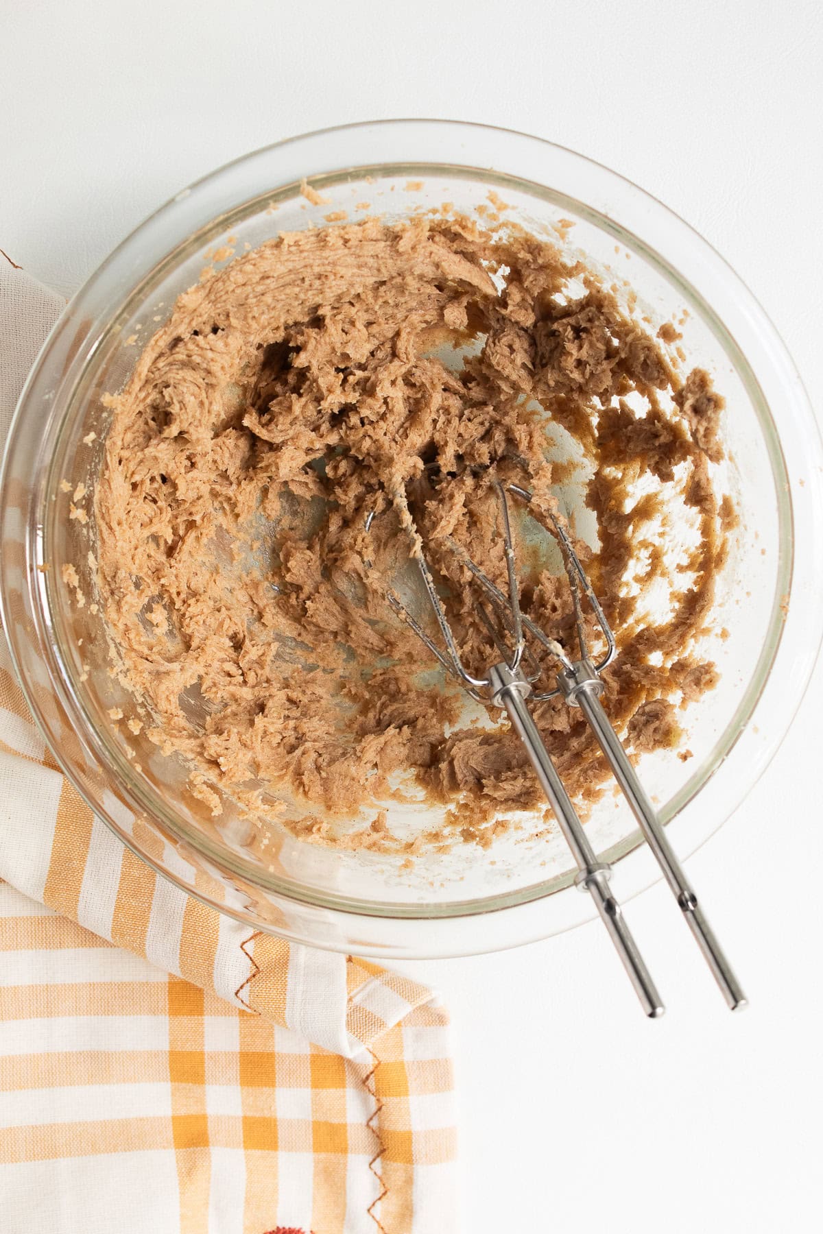 The butter, brown sugar, and pumpkin spice are whipped together in a medium bowl.