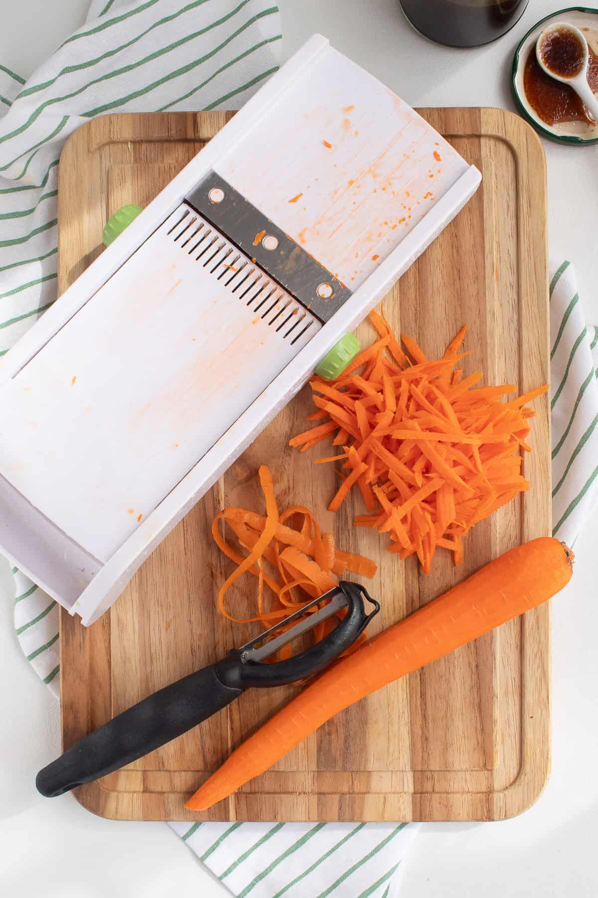 Carrots are shredded using a peeler and a mandoline.