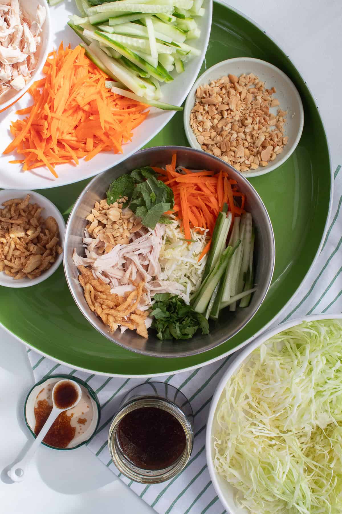 Salad ingredients are collected in a silver bowl before tossing with the vinaigrette.