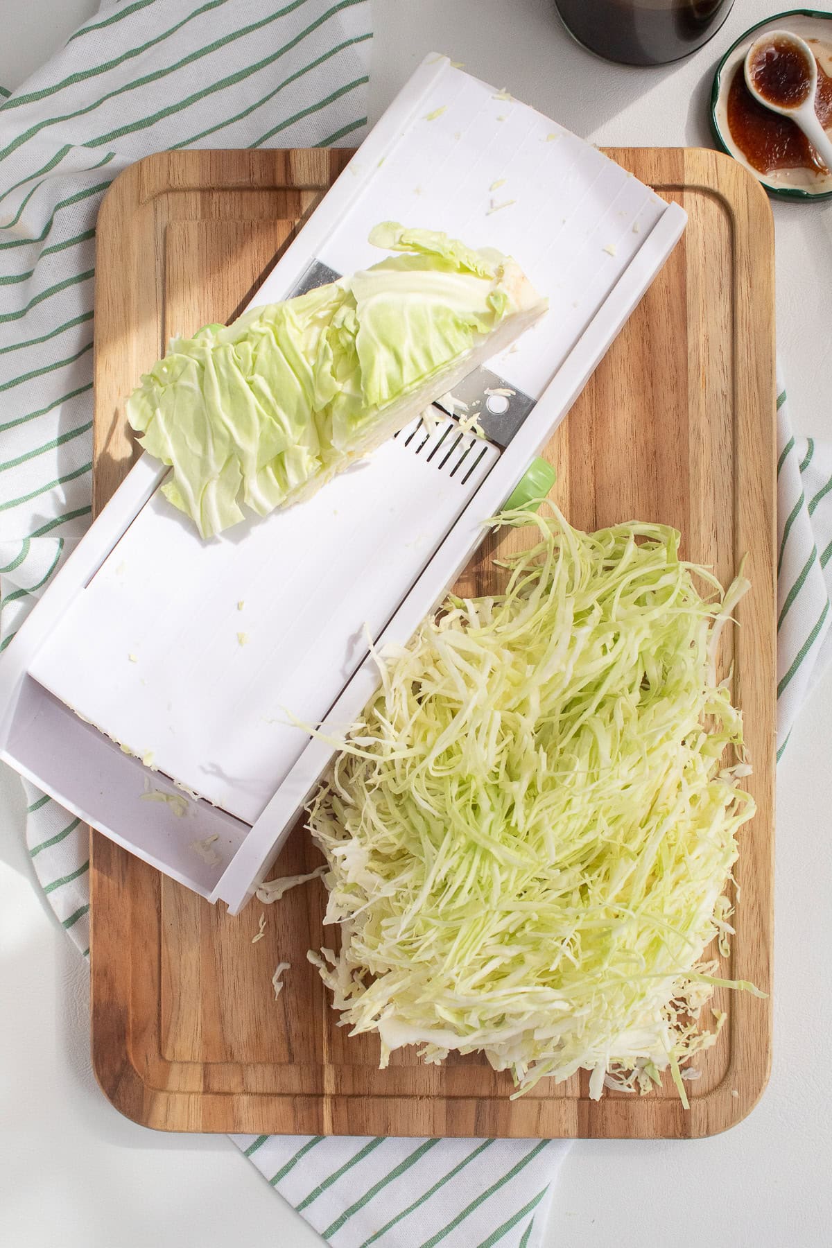 Shredded cabbage is prepared suing a mandoline.