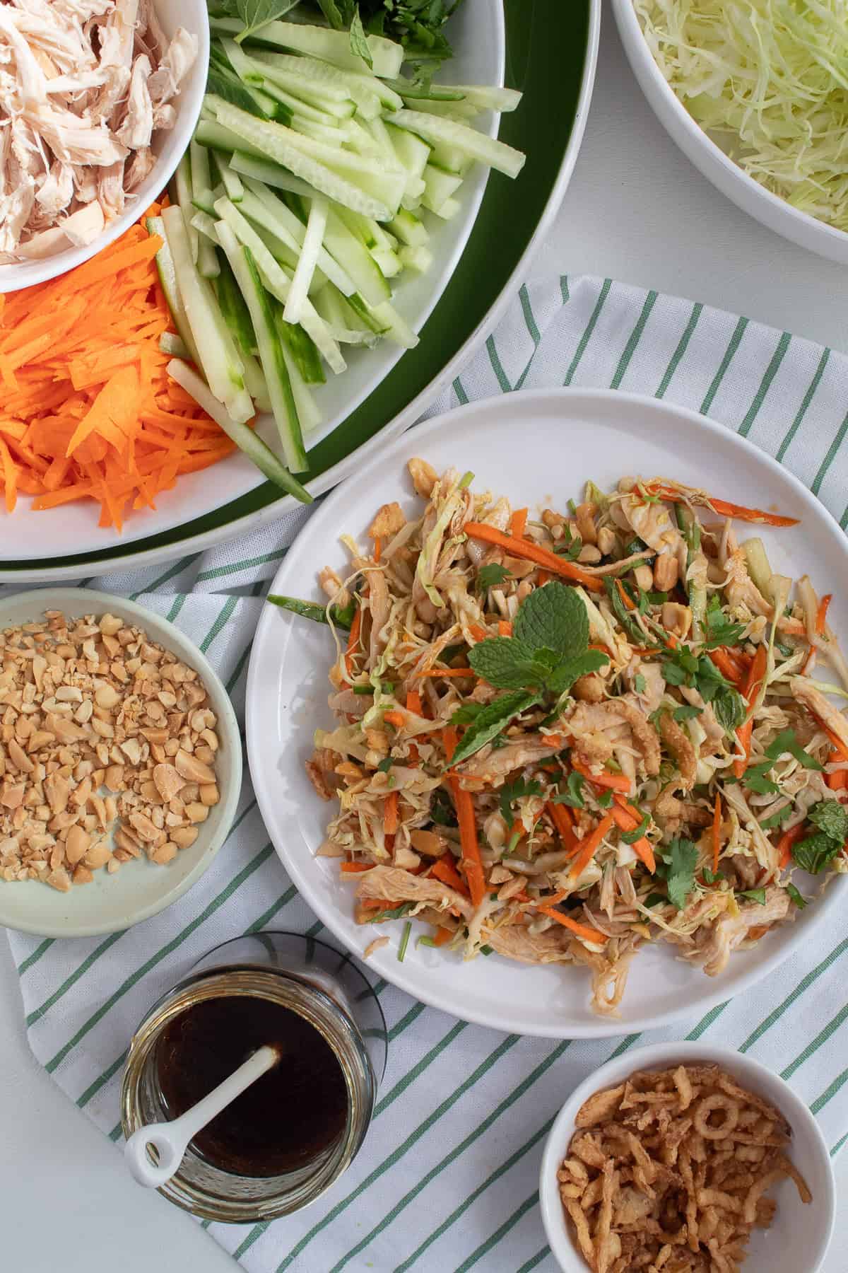 The salad is served on a white plate with all of the salad components surrounding it.
