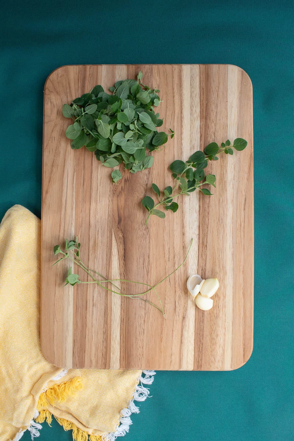 Oregano is prepared by stripping the leaves from the stem and garlic is peeled.