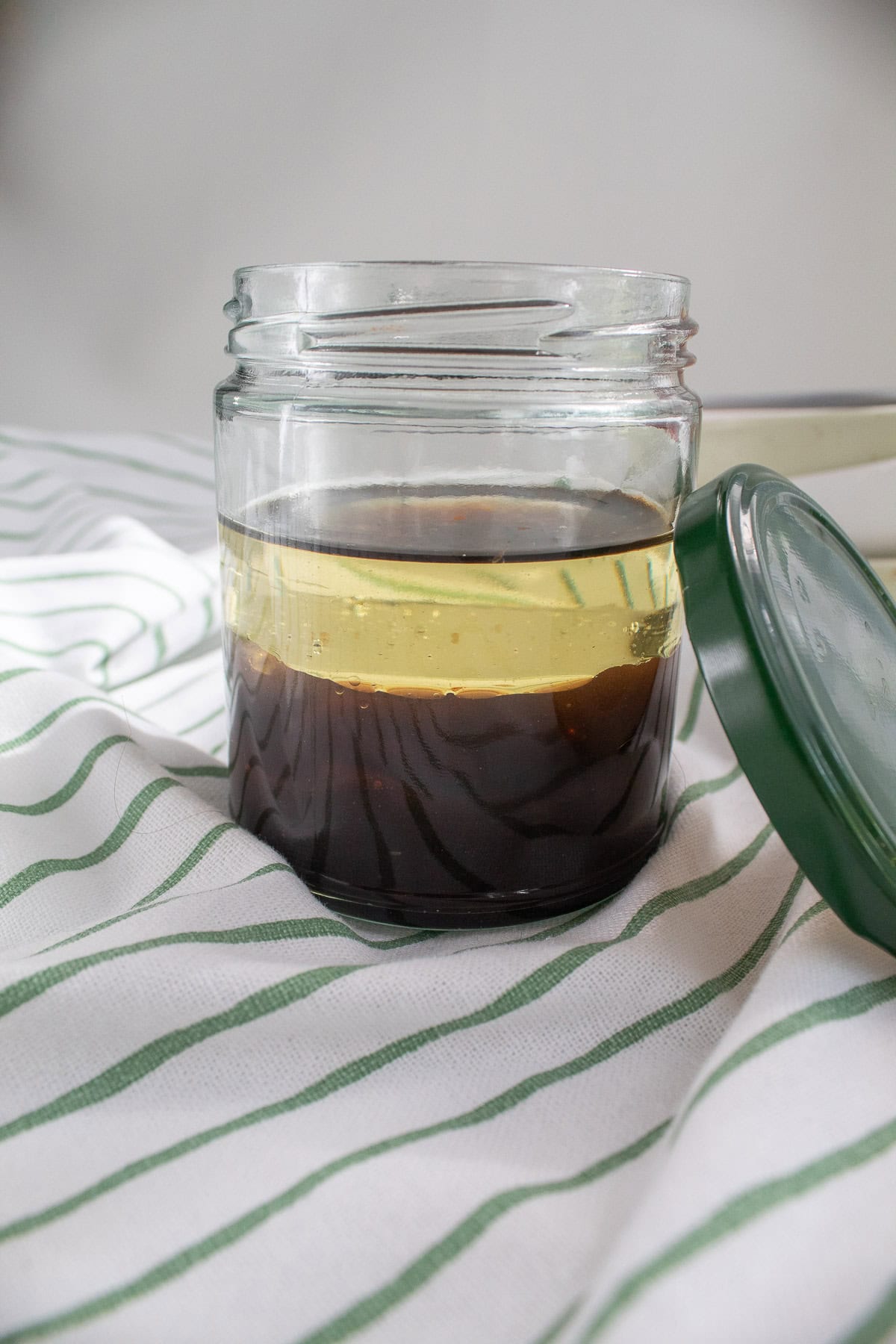 The ingredients for the vinaigrette are layered in a jar.