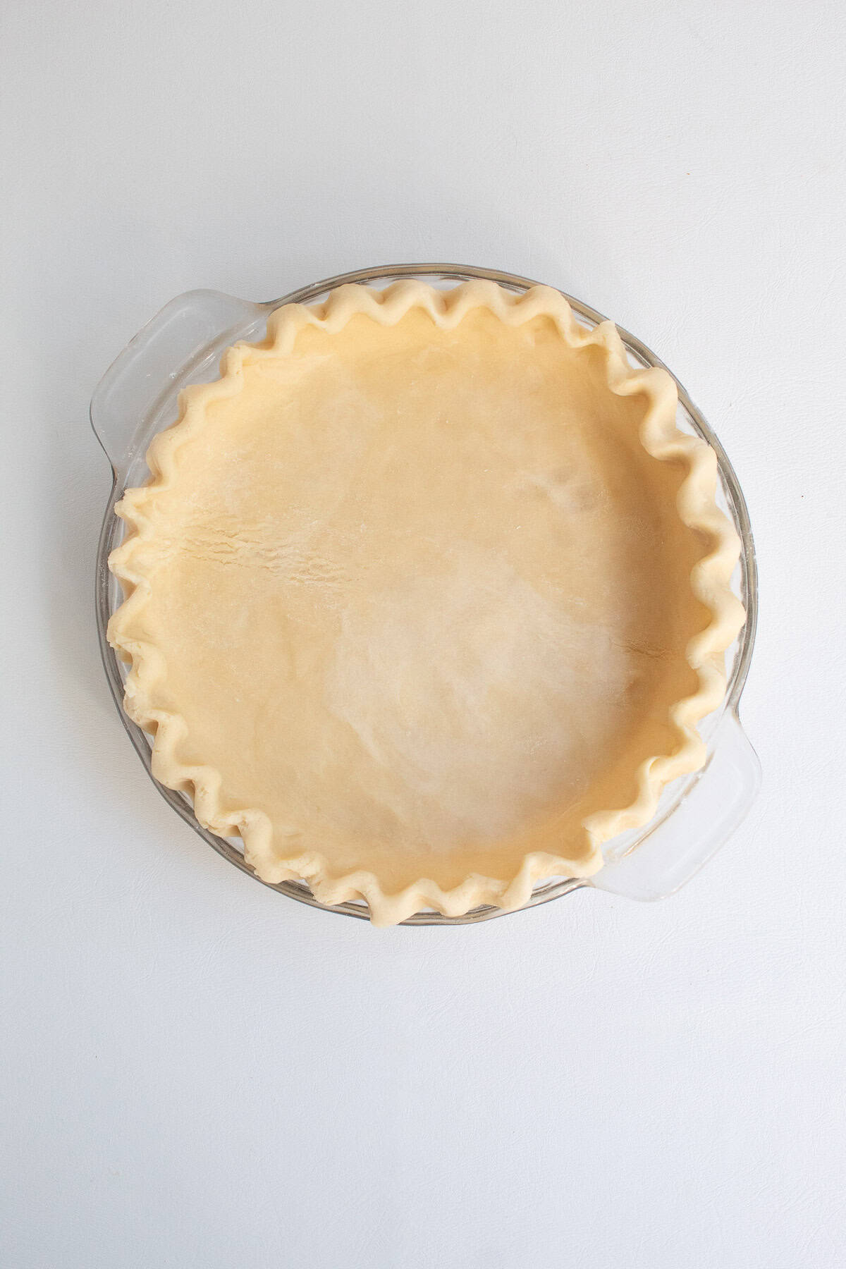 The fully crimped pie crust is ready for baking.
