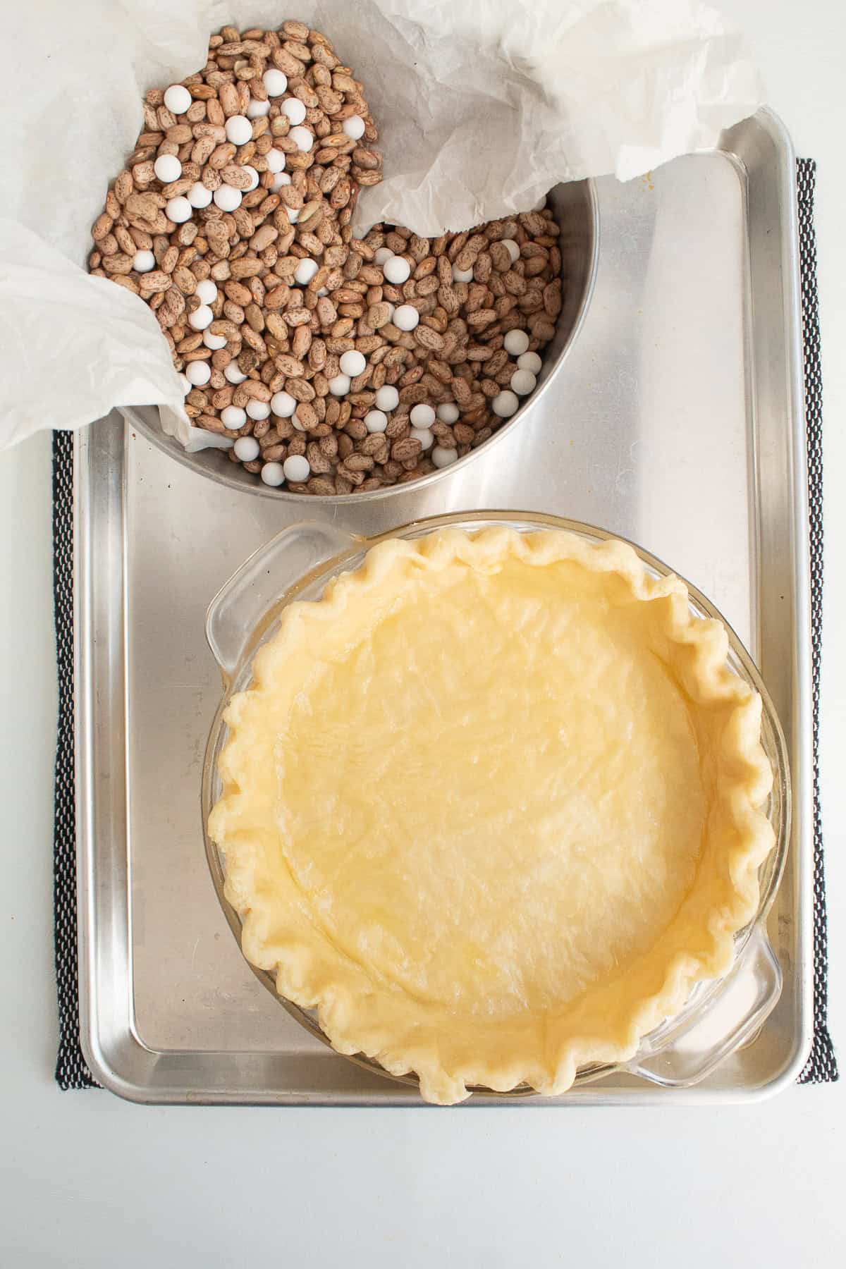 The pie crust has been partially baked and the pie weights have been removed.