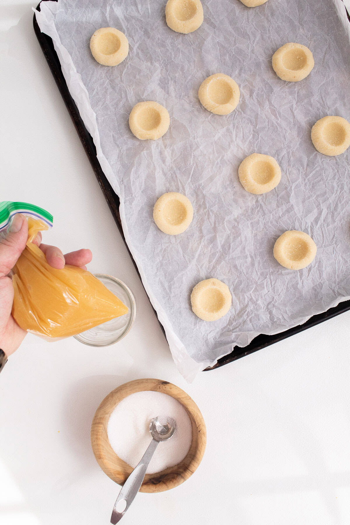 Lemon curd is added to a zip-topped bag f easy filling of the thumbprint cookies.