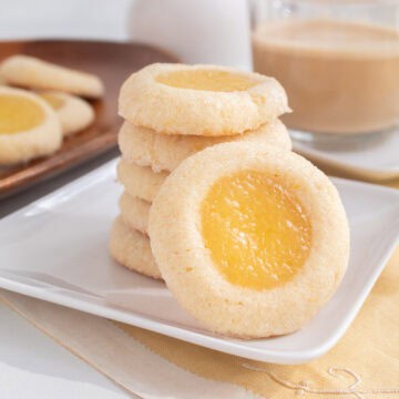 A stack of baked cookies features golden edges and a sunny yellow filling.