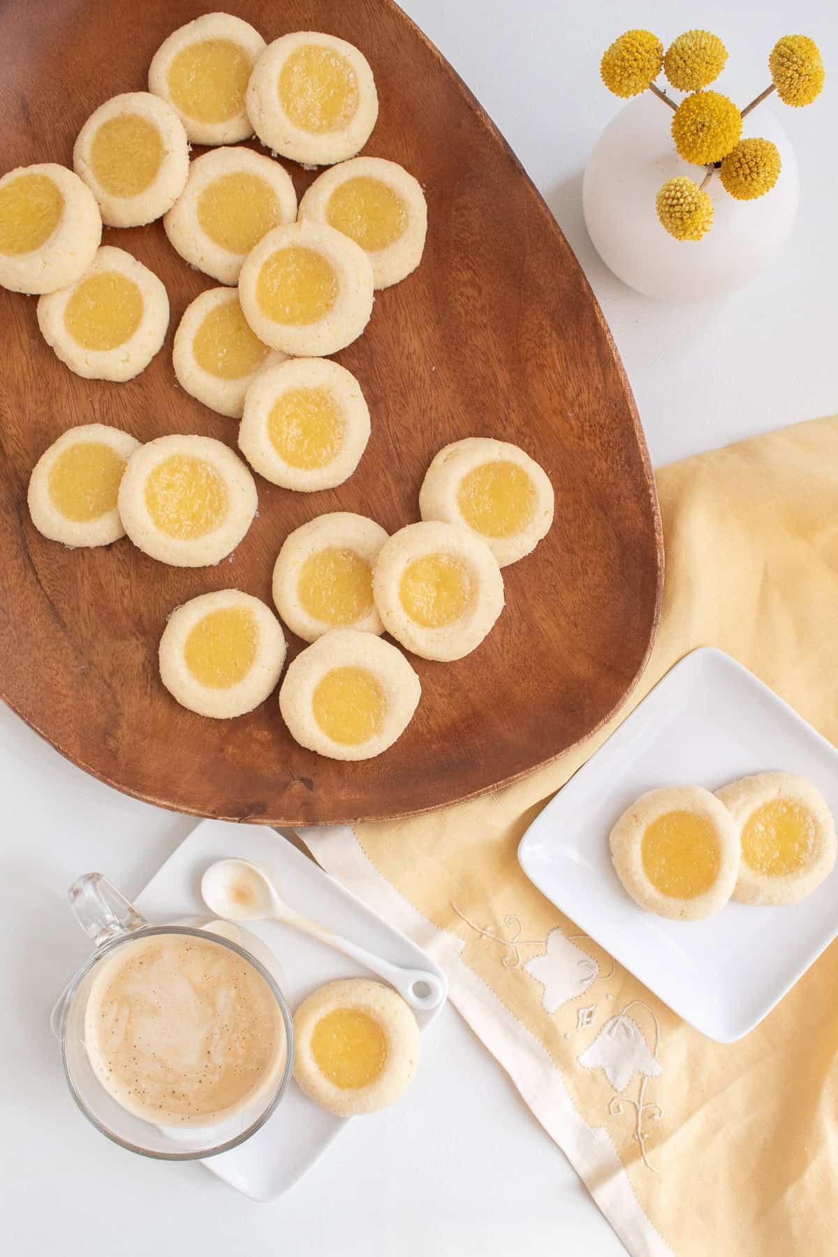 Cookies are served on a wooden platter alongside coffee.