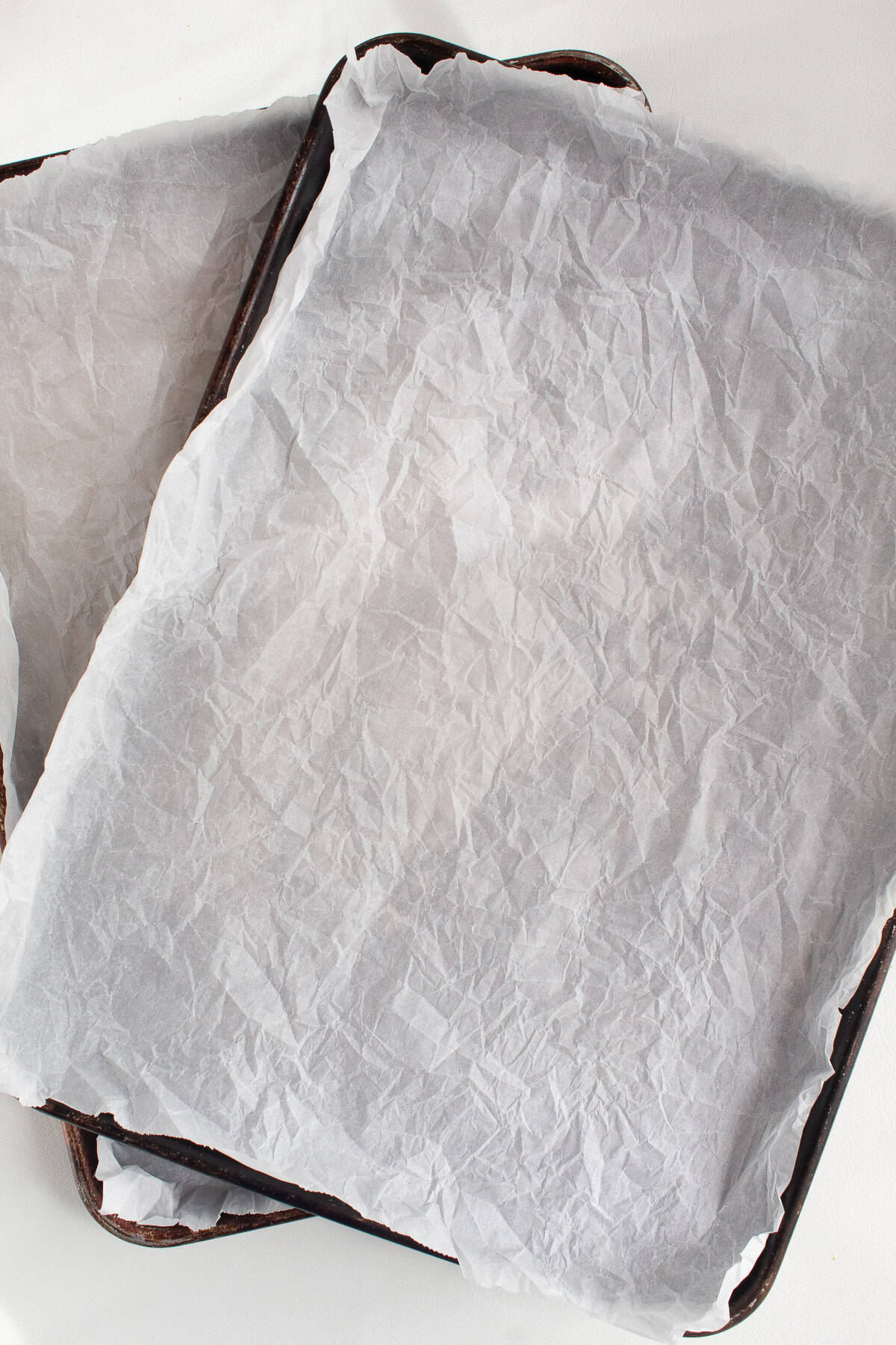 Two sheet pans are lined with parchment paper.