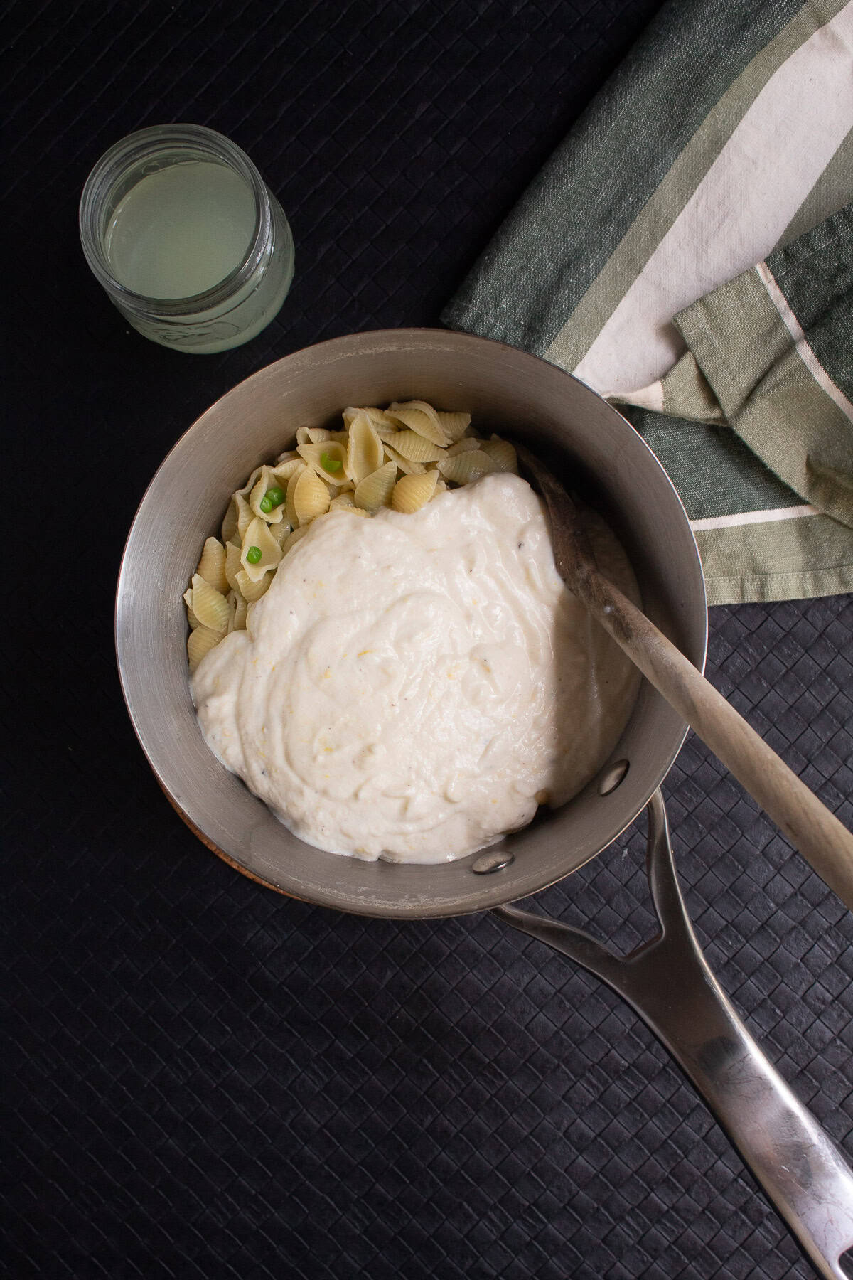 The creamy ricotta sauce is poured over the pasta in the saucepan.