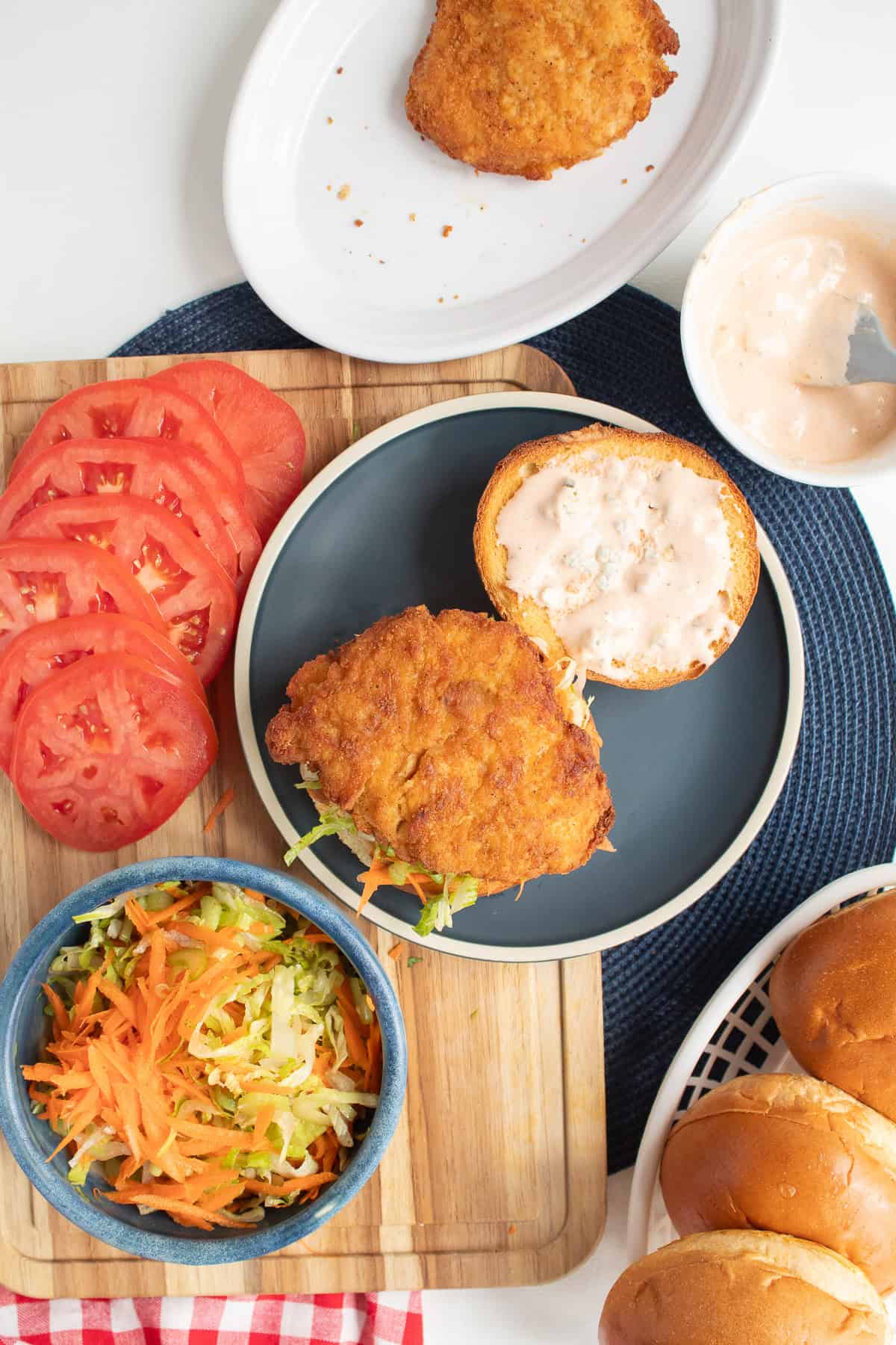 A crispy breaded chicken breast is placed over the slaw on the bottom half of the bun.