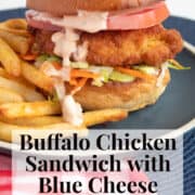 The buffalo chicken sandwich is piled high and dressed with blue cheese sauce. A white text box at the bottom of the image contains the words, "buffalo chicken sandwich with blue cheese sauce" and "plan. eat. post. repeat."