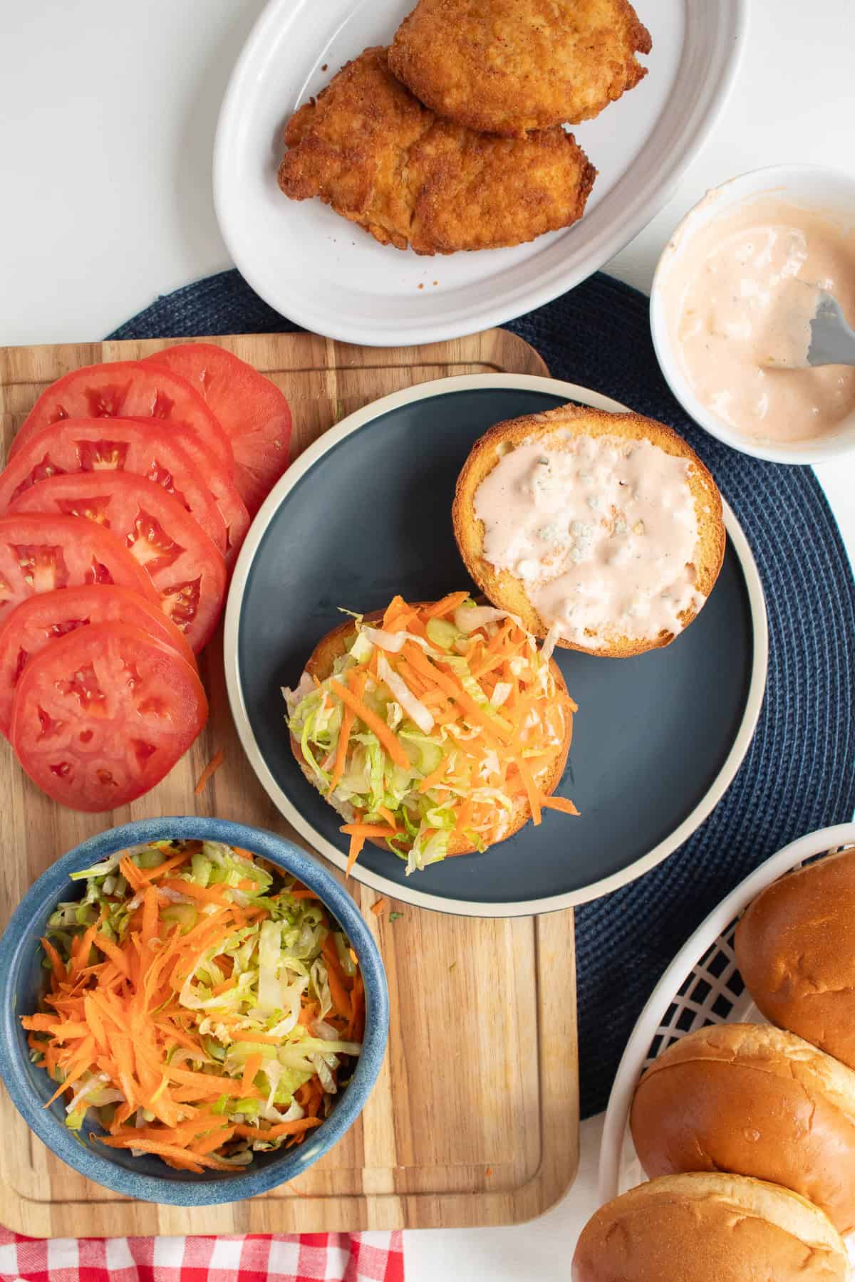 A pile of slaw is added to the base of the sandwich bun.