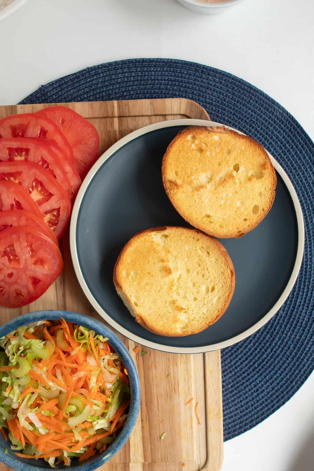 The brioche bun is split and toasted to a golden brown.