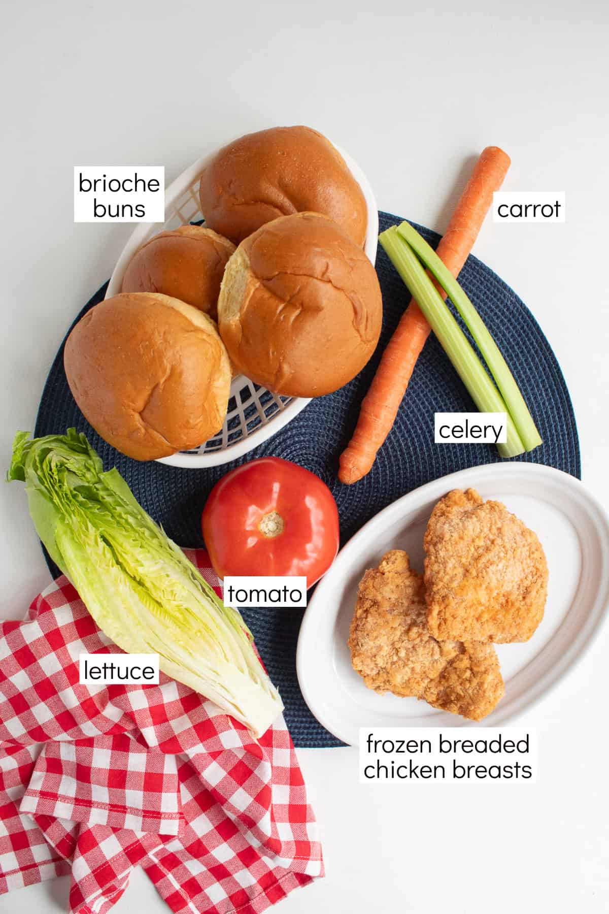 Ingredients for the blue cheese sauce are displayed and labeled with white text boxes including the words brioche buns, carrot, celery, tomato, lettuce, and frozen breaded chicken breasts.