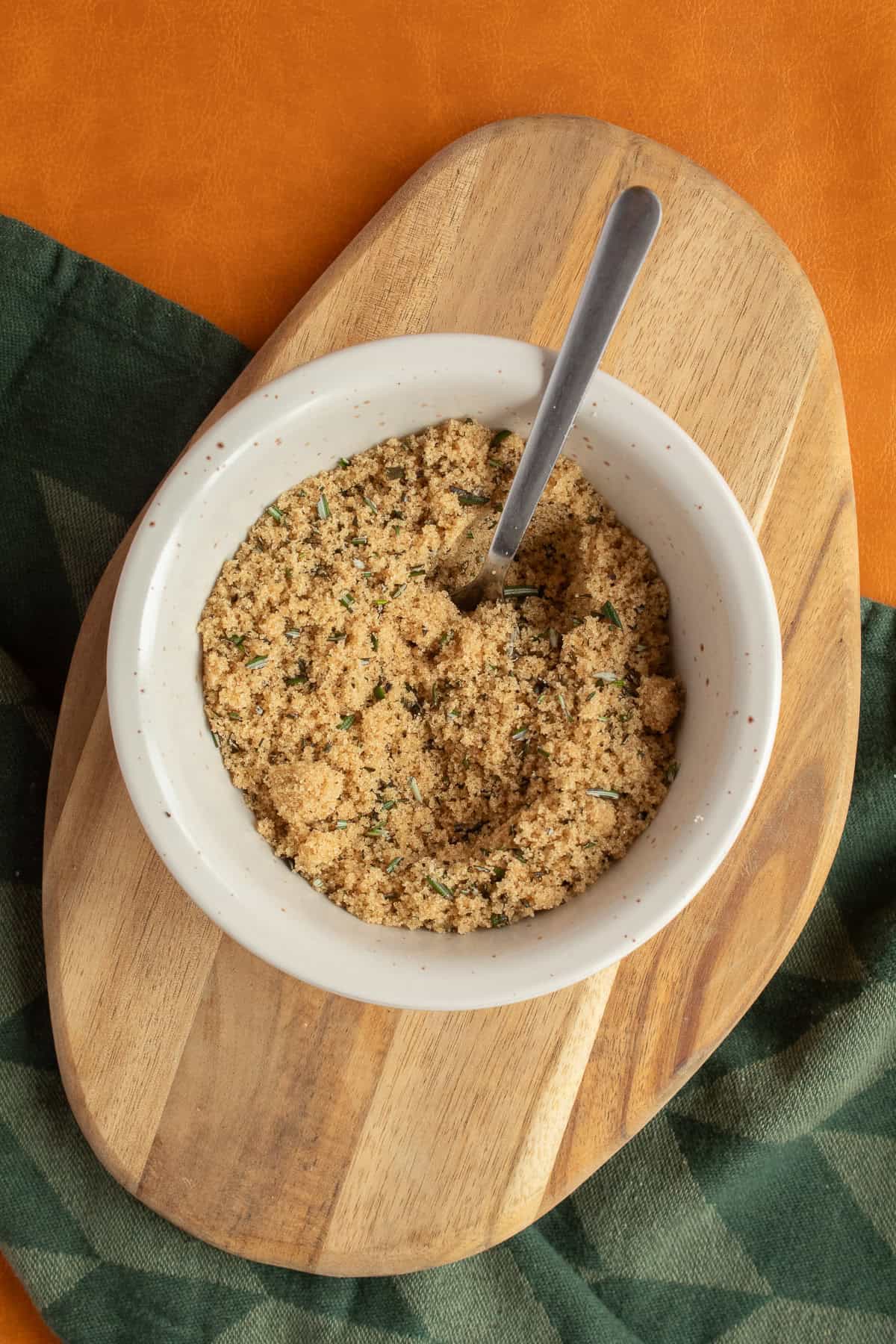 Brown sugar, rosemary, and black pepper are thoroughly combined in a small bowl.