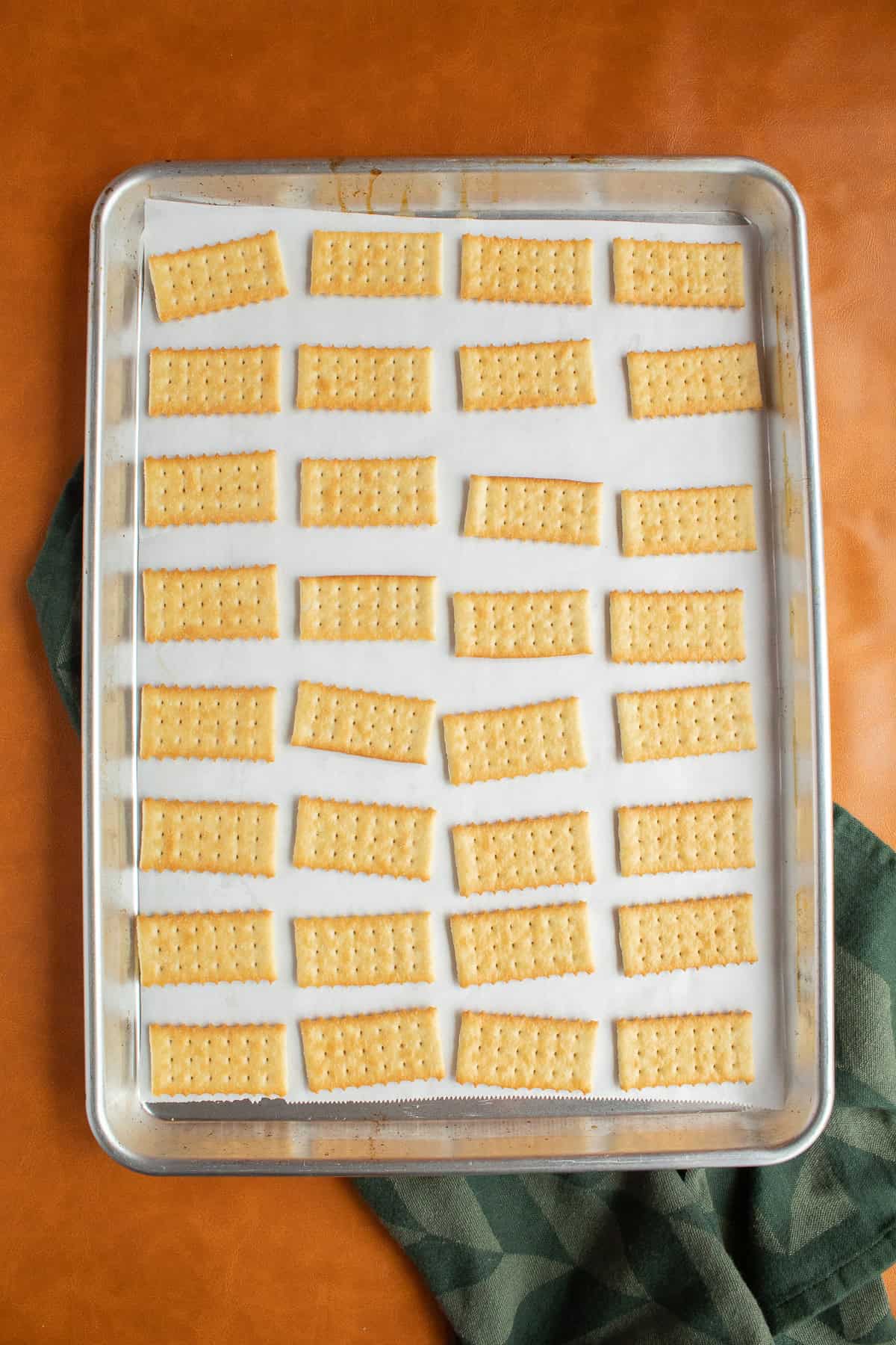 Buttery crackers are lined up on the sheet pan.